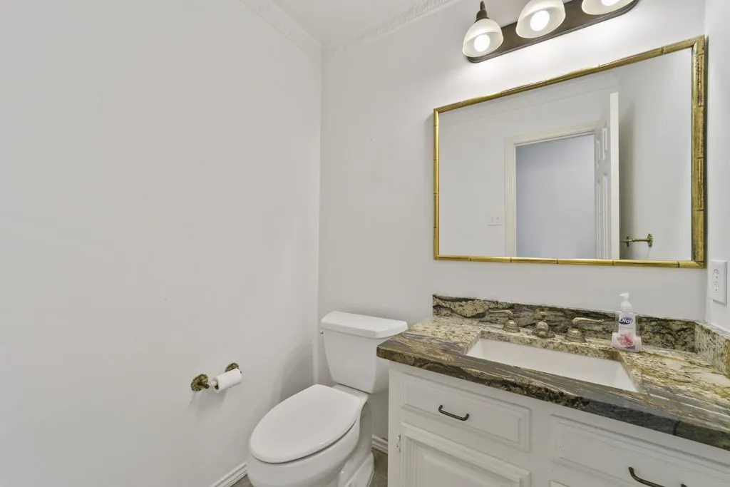 White vanity with dual doors and drawers, featuring a built-in sink and a patterned countertop