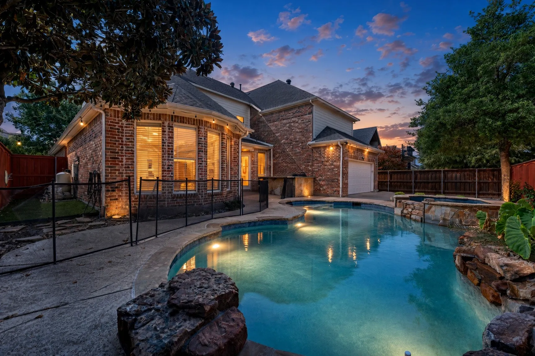 Brick exterior with bay windows and a private swimming pool, featuring integrated lighting, a spa, and stone accents