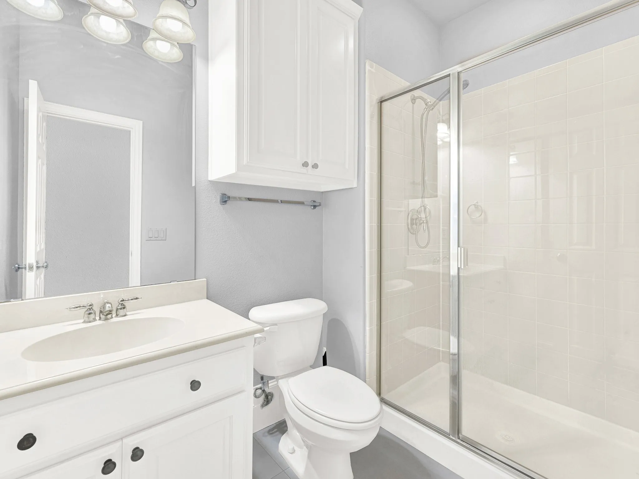 White vanity with an integrated sink, polished chrome faucet, and storage cabinetry