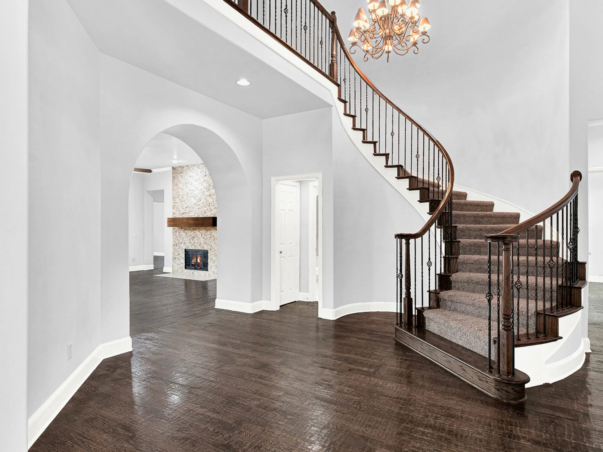 Gracious curved staircase with wrought iron balusters