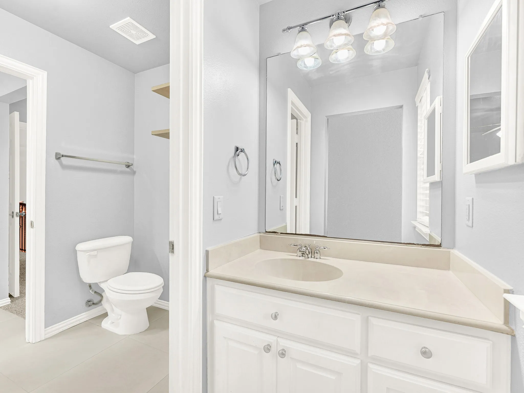 White vanity with an integrated sink and light-toned countertop
