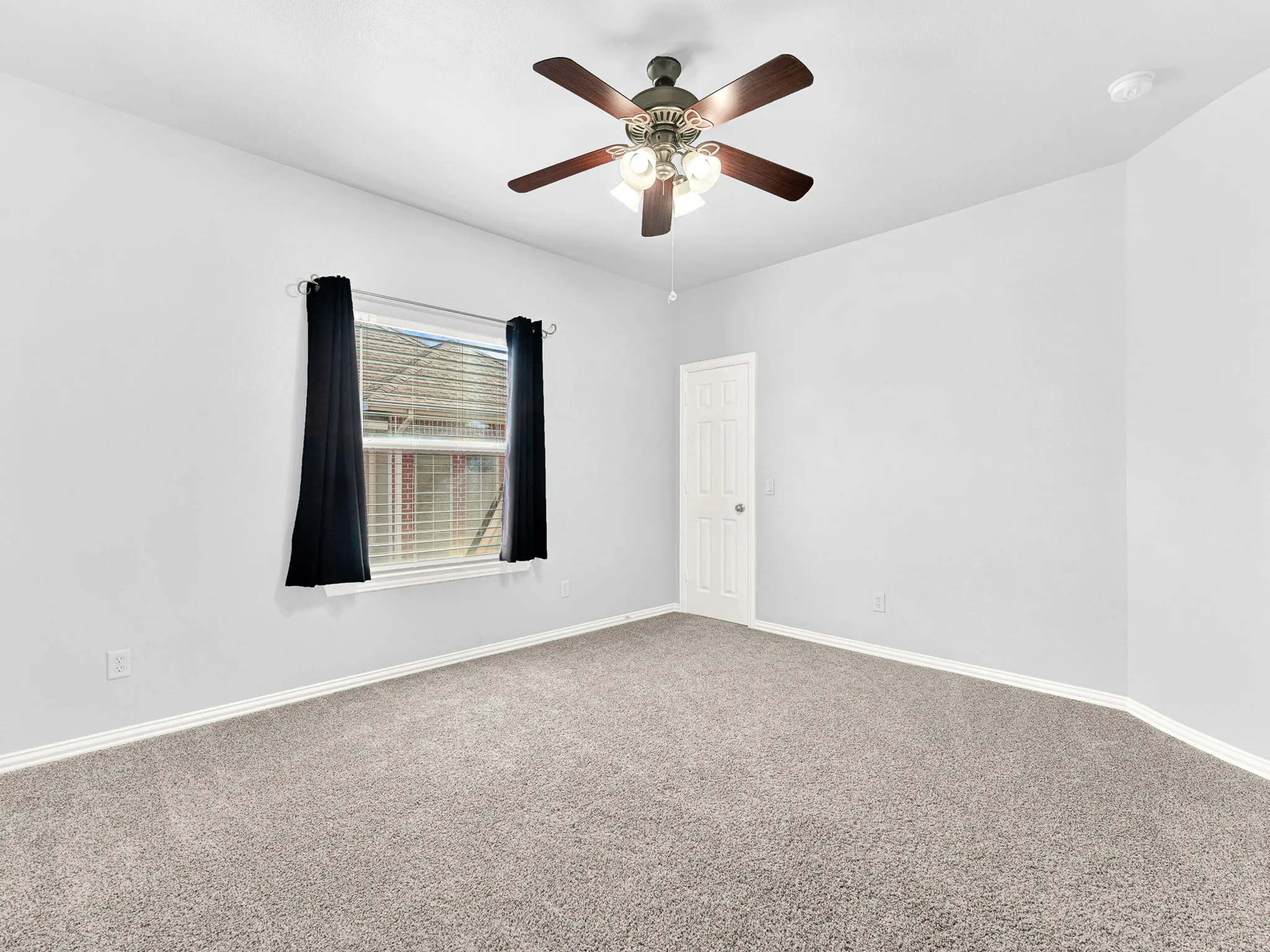 Carpeted room featuring a ceiling fan with integrated lighting, a paneled door, and a window with horizontal blinds