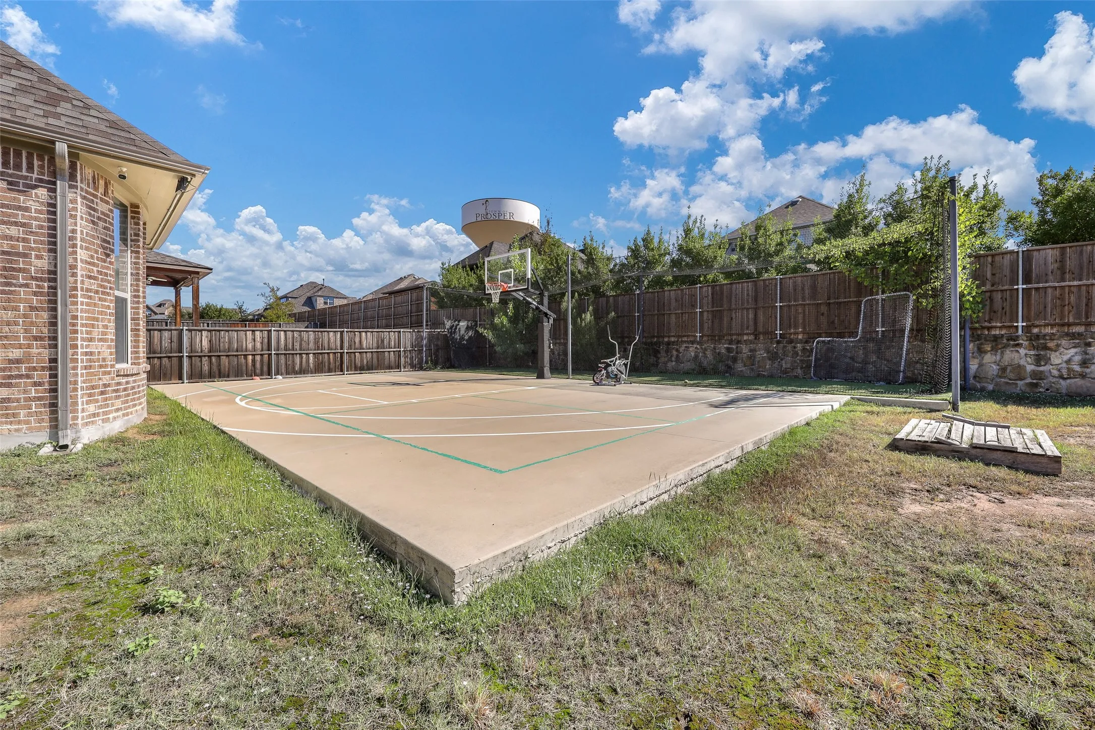 Back yard includes large sport court and batting cage