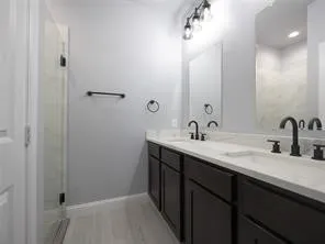 Ensuite bathroom to primary bedroom with shower and double sinks.