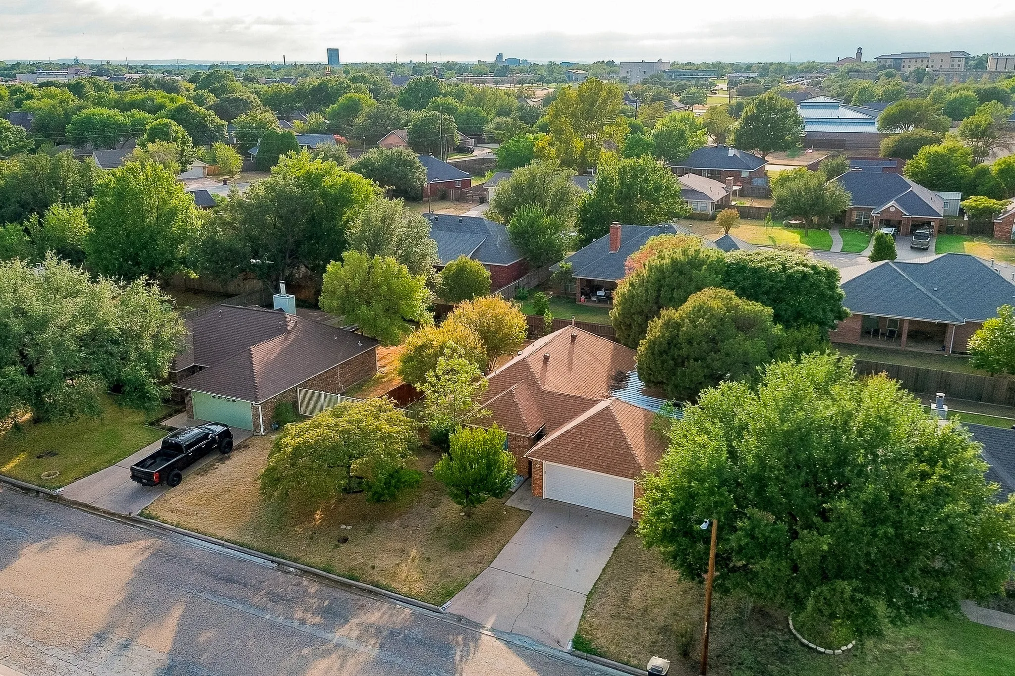 Single-story residence with a brown shingle roof, attached garage, and a concrete driveway