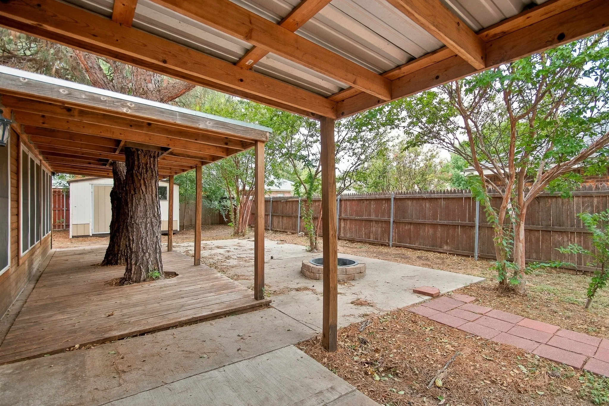 Covered outdoor living space with exposed wood beams and a metal roof