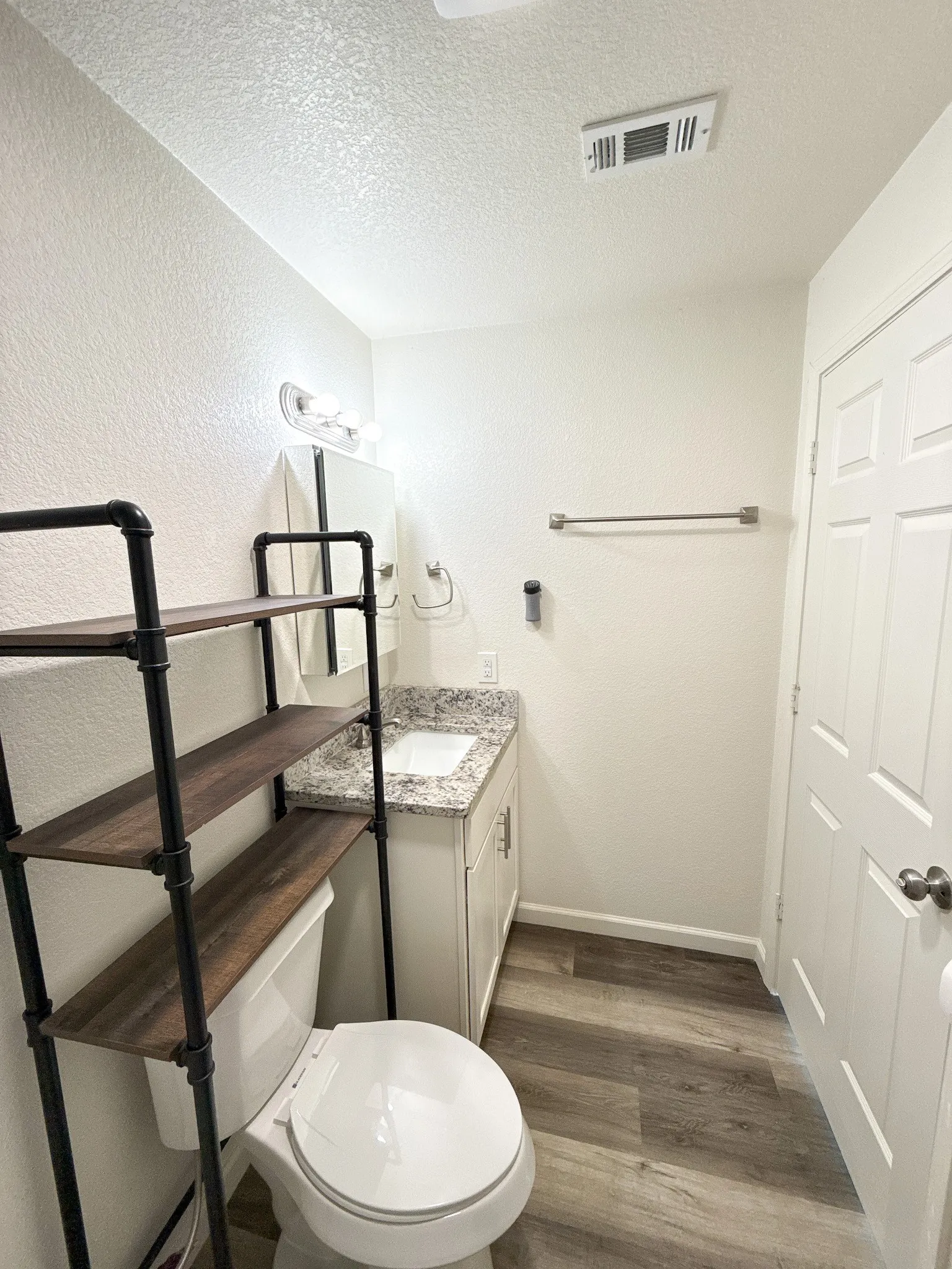 Primary ensuite bathroom with granite counter vanity in this Oglesby, Texas home