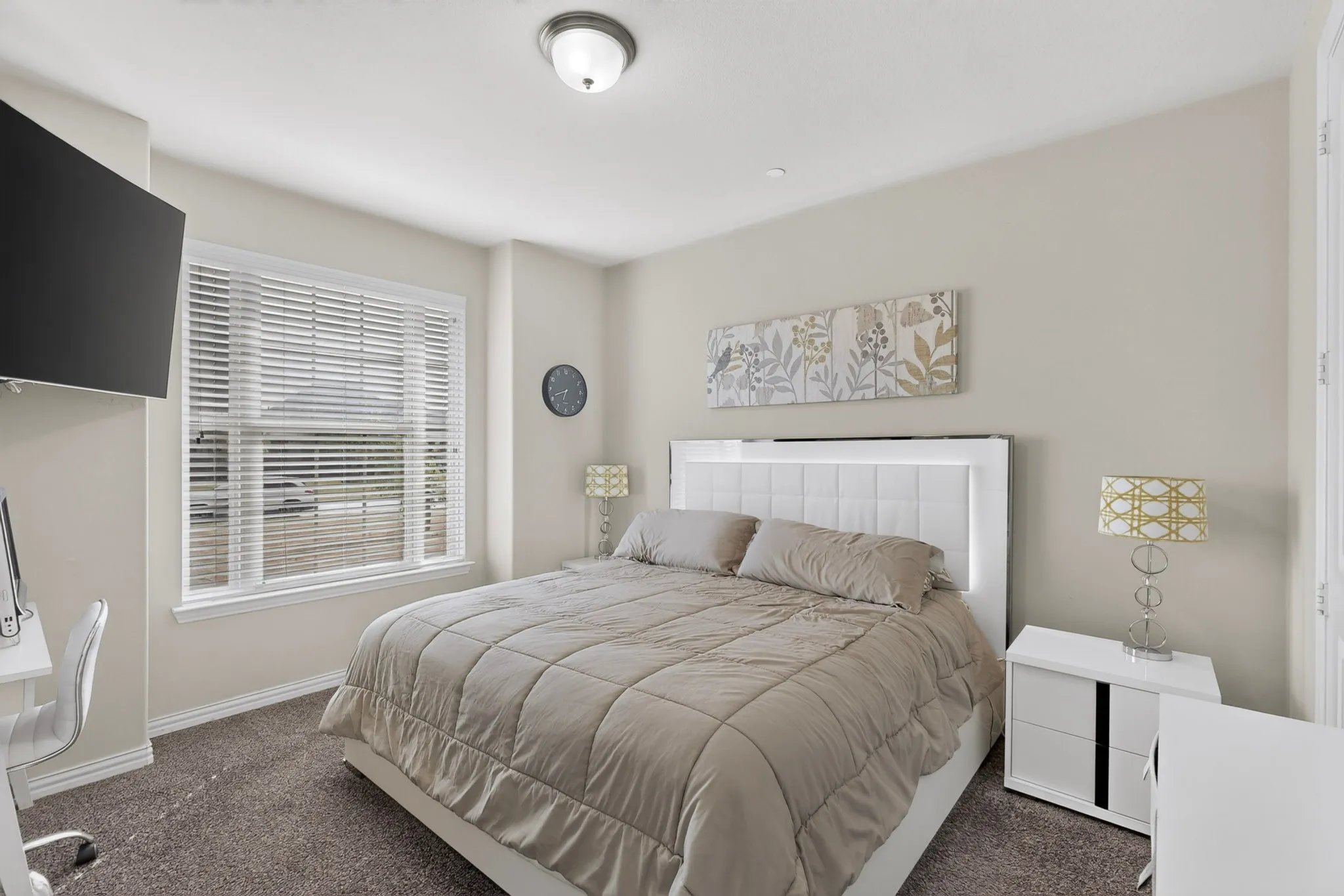 Downstairs Carpeted room with a ceiling-mounted light fixture, a window with blinds, and a built-in wall niche