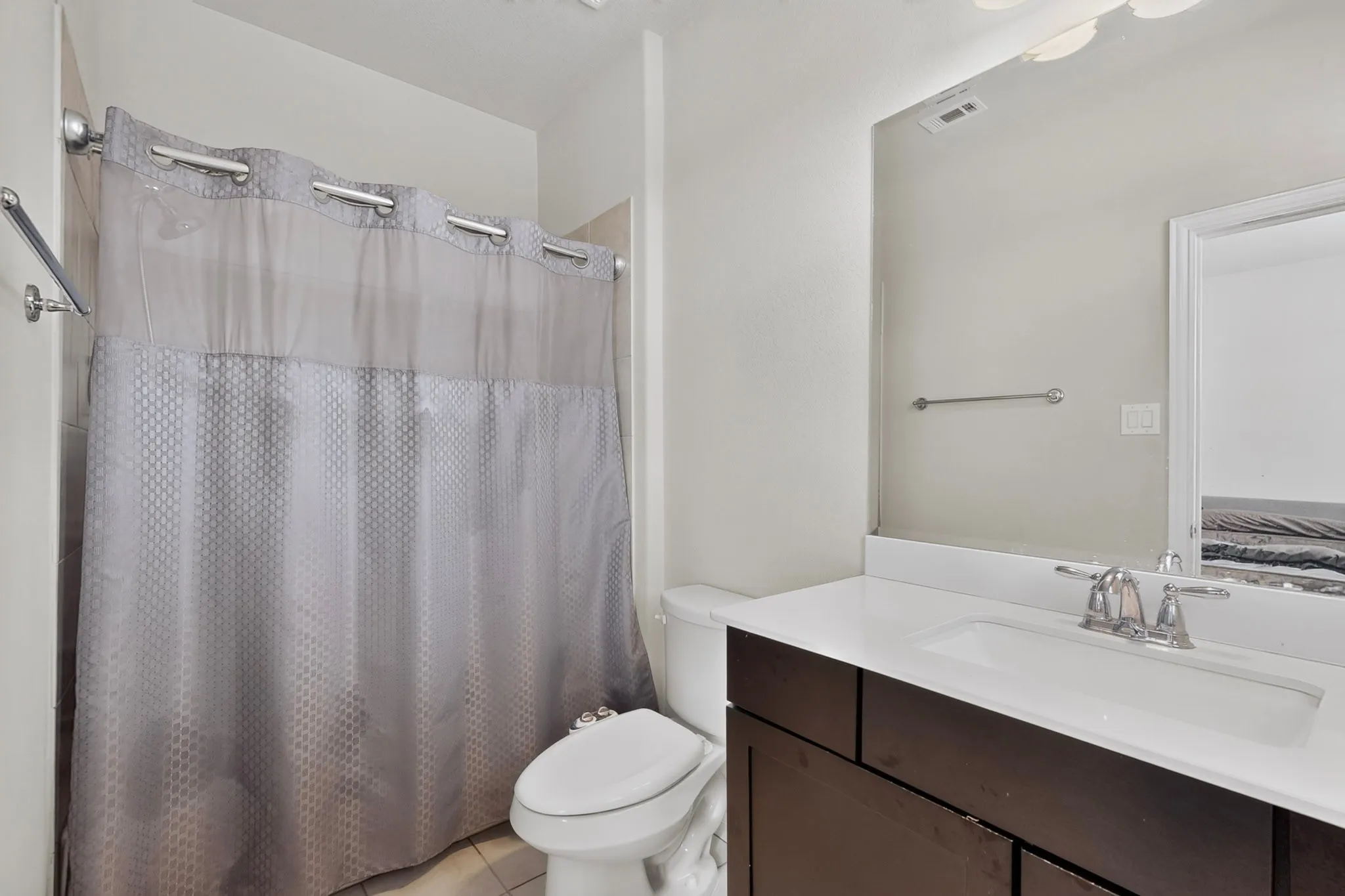 Bathroom featuring a single vanity with a white countertop, chrome faucet, and integrated sink