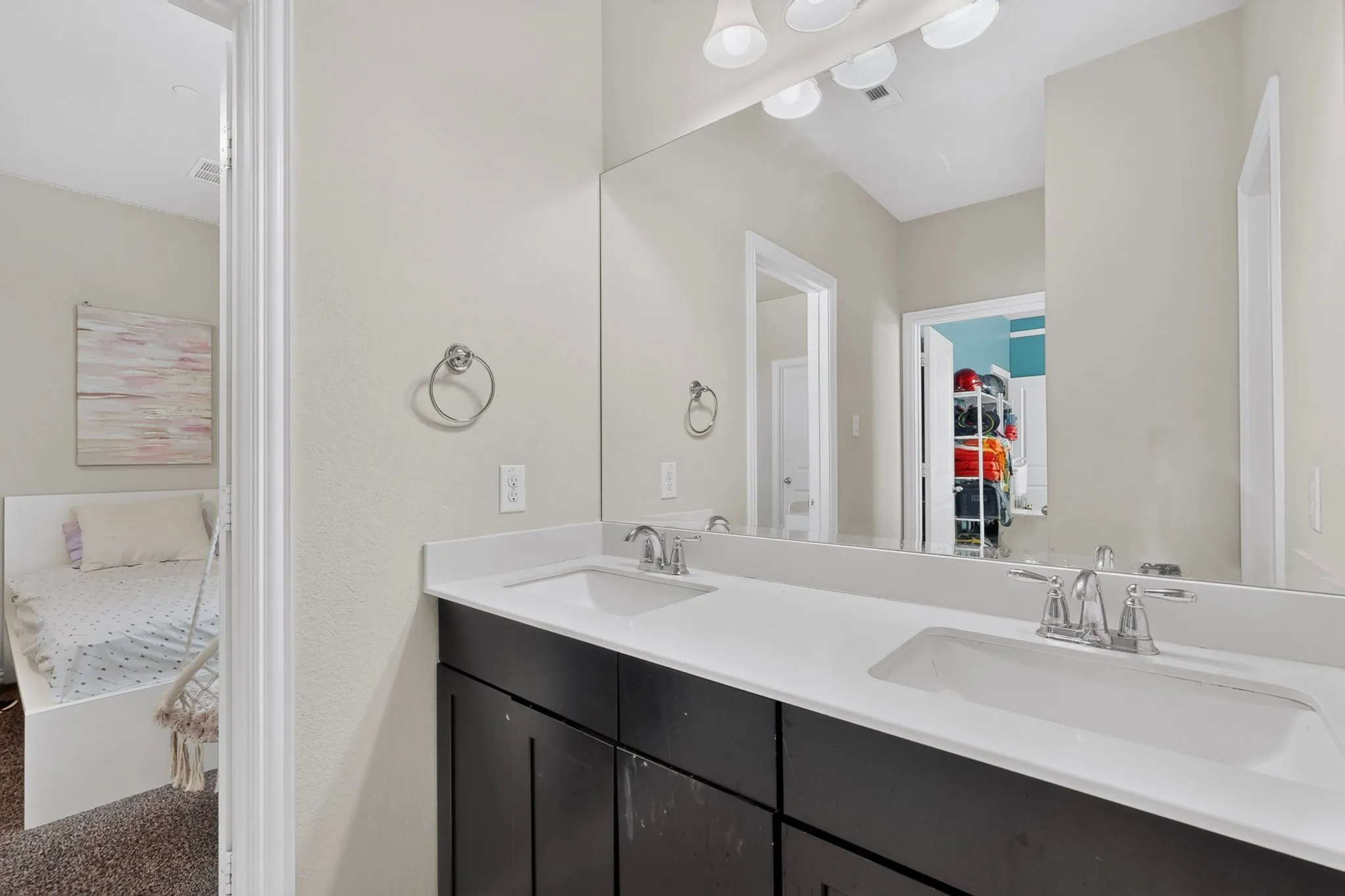 Dual vanity with white countertop, integrated sinks, and dark wood-finish cabinetry