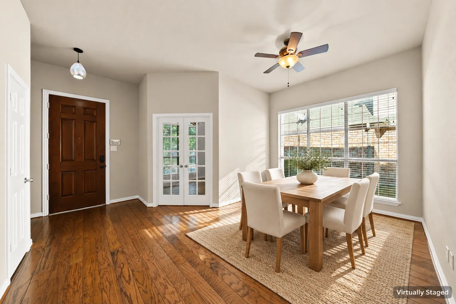 Wood-finish flooring throughout, a six-panel solid wood entry door, and French paneled doors
