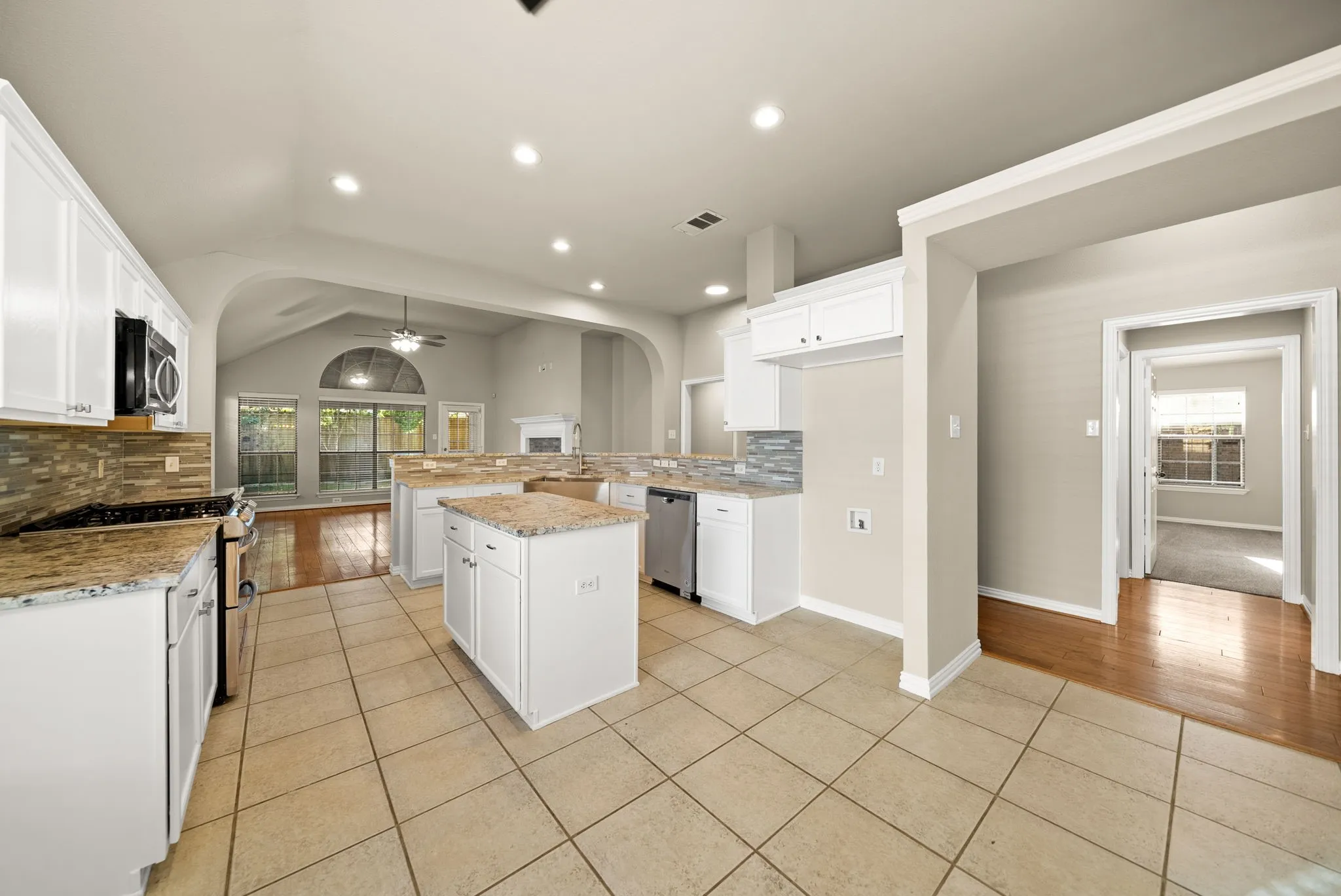 Kitchen featuring white cabinetry, granite countertops, tile flooring, and stainless steel appliances