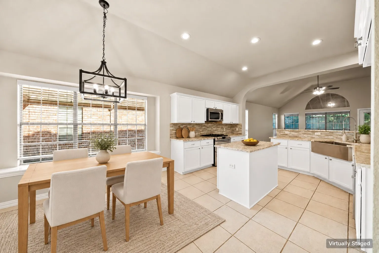 Kitchen featuring white cabinetry, a central island, stainless steel appliances, stone countertops, and tile flooring