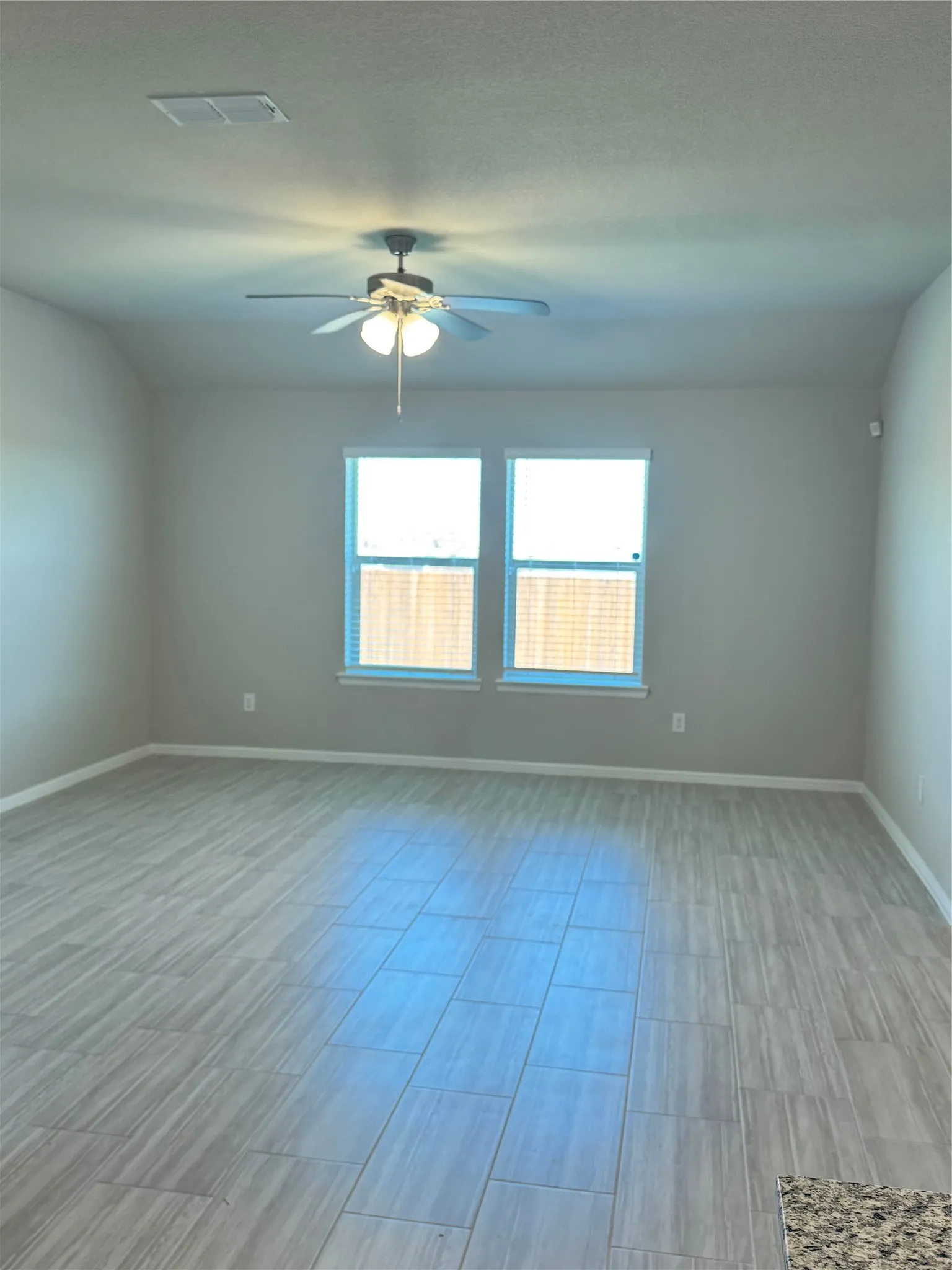 Unfurnished living room with a ceiling fan and wood finish floors