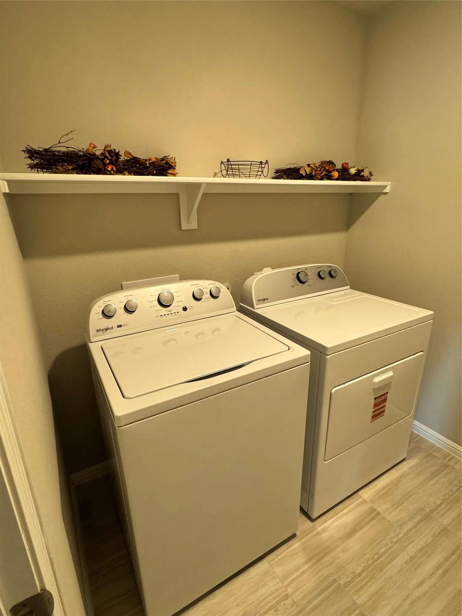 Washroom with baseboards and whirlpool washing machine and dryer included.