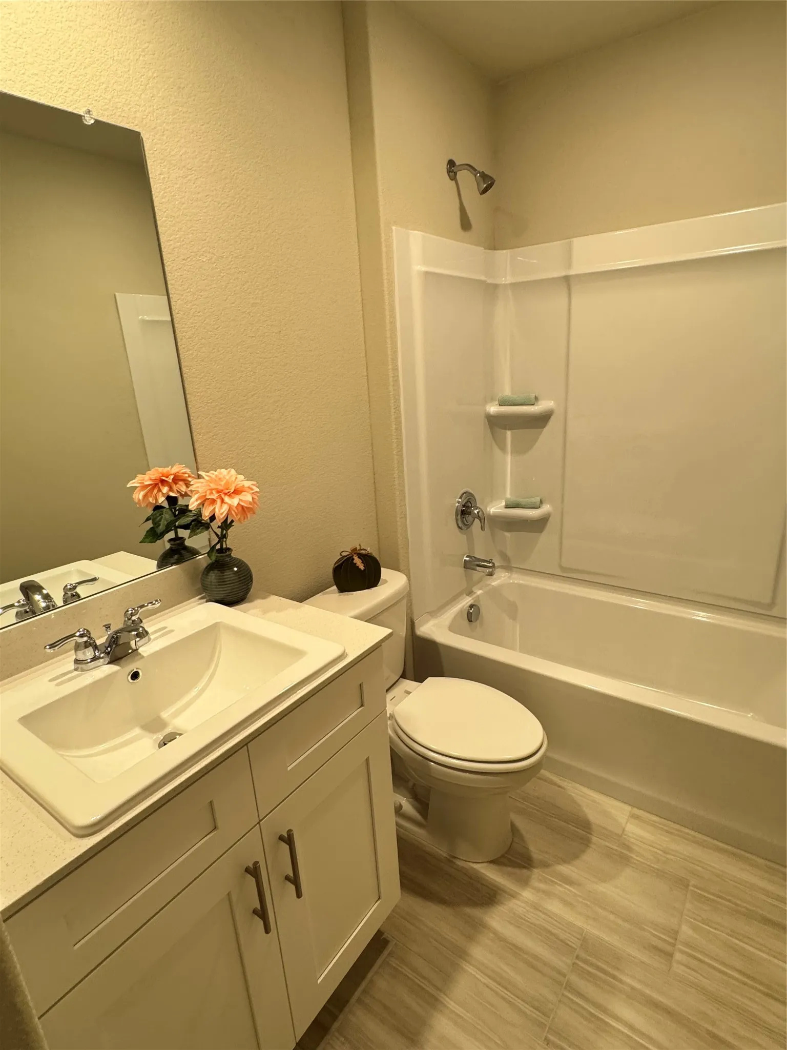 Bathroom with vanity, a textured wall, and  shower​​‌​​​​‌​​‌‌​‌‌​​​‌‌​‌​‌​‌​​​‌​​ combination