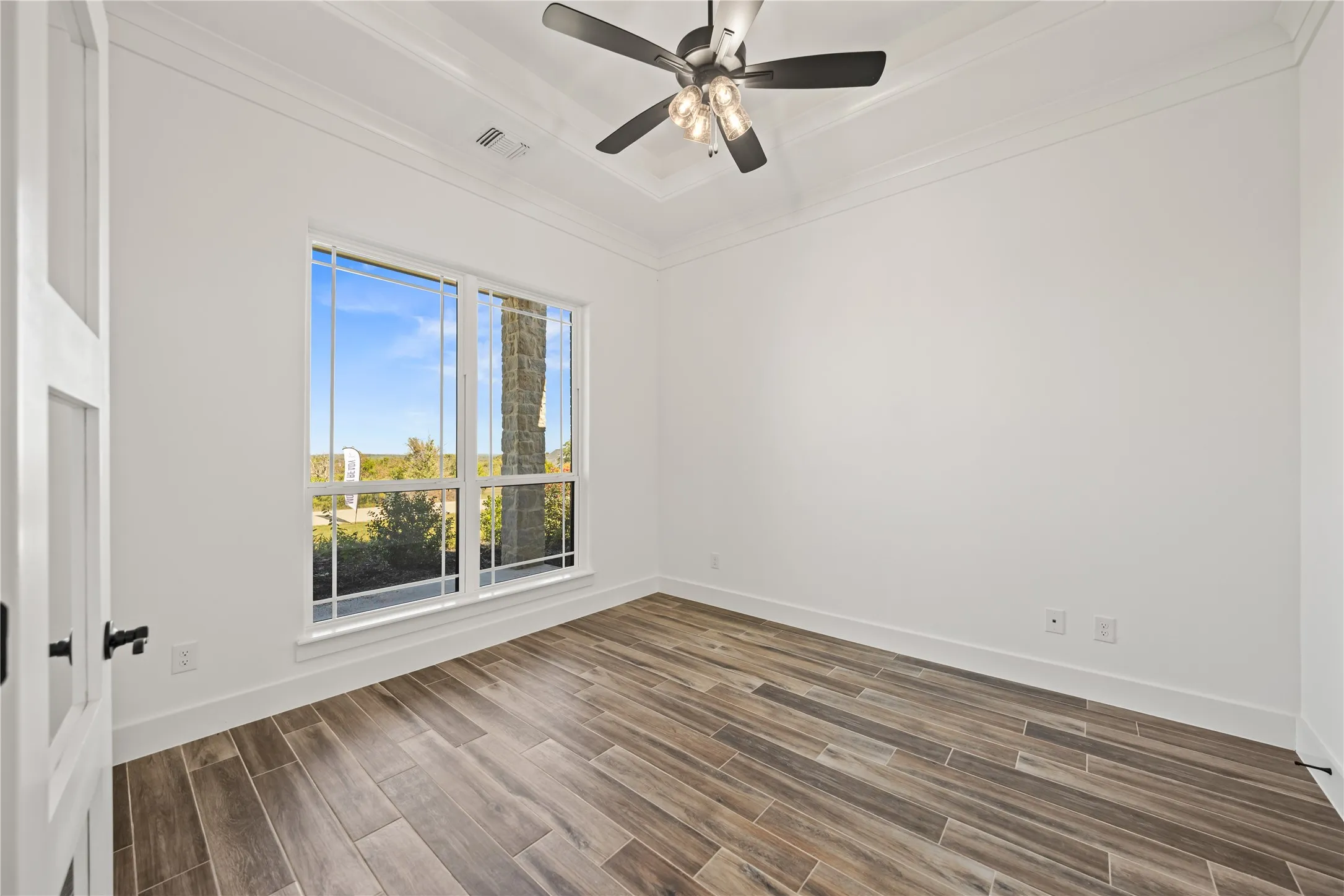 Wood-finish flooring, white walls, and a multi-pane window