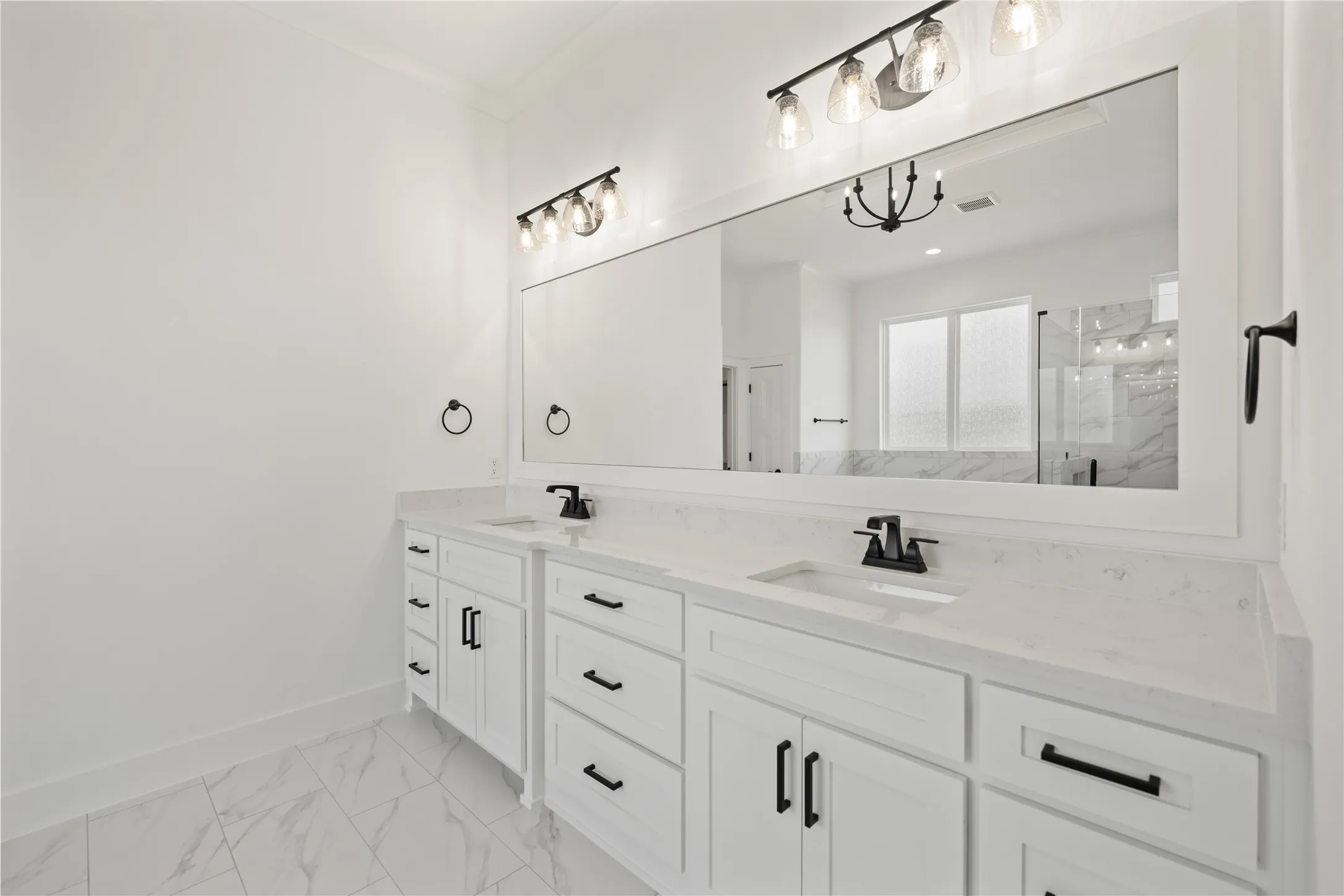 Dual vanity featuring white cabinetry and countertops