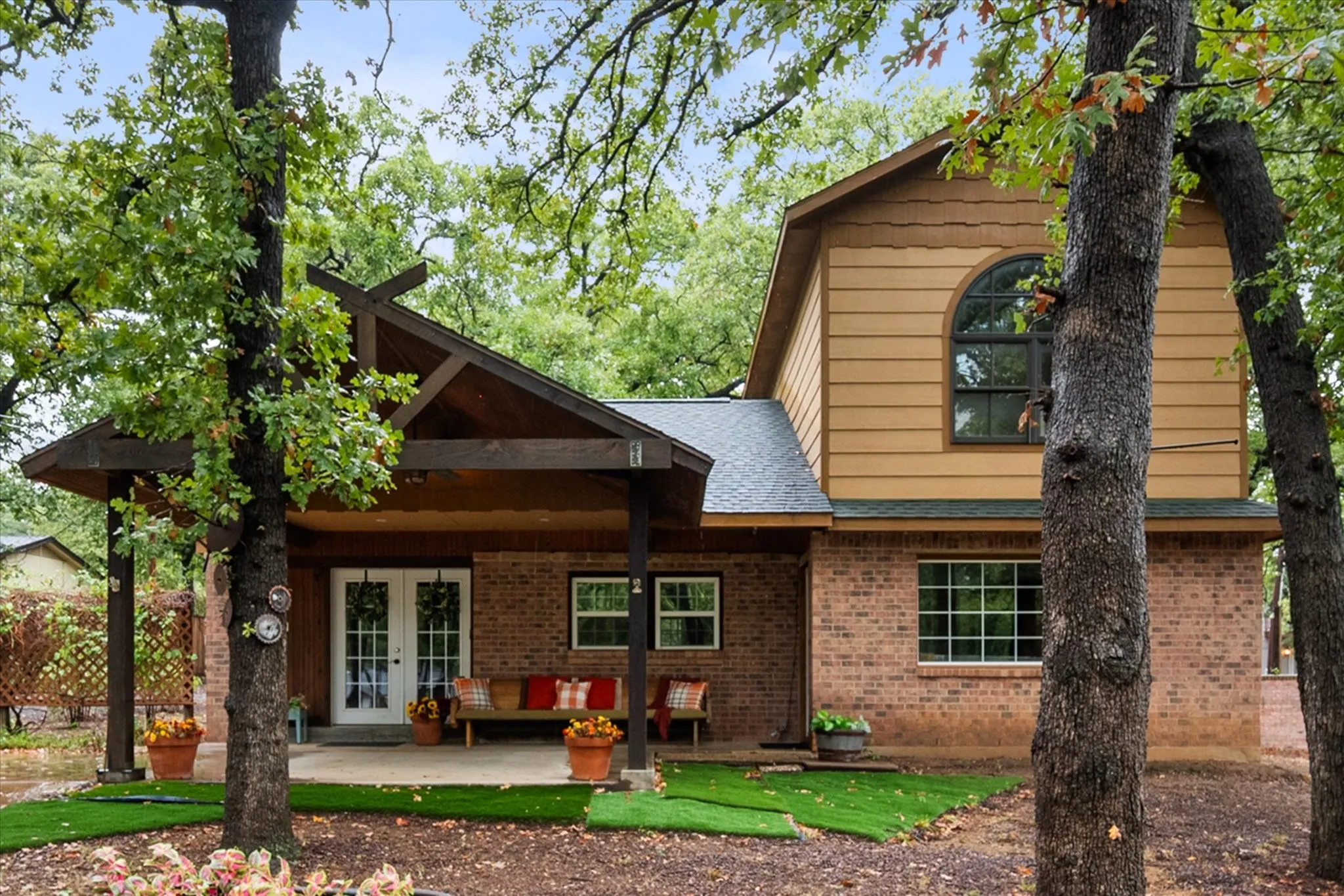 Brick and siding exterior with a covered front porch featuring exposed wood beams
