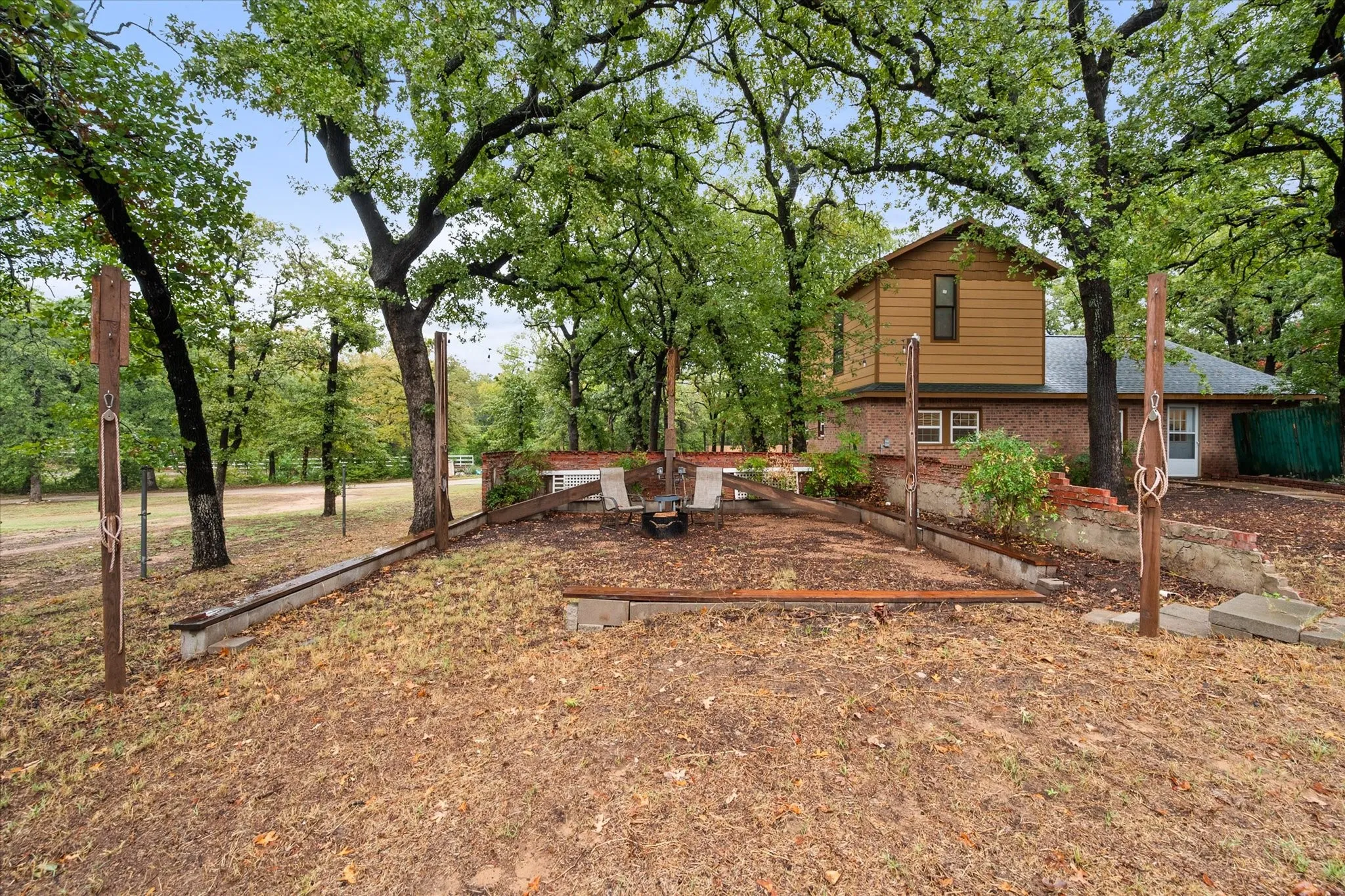 Brick and siding exterior with a multi-level design, surrounded by mature trees
