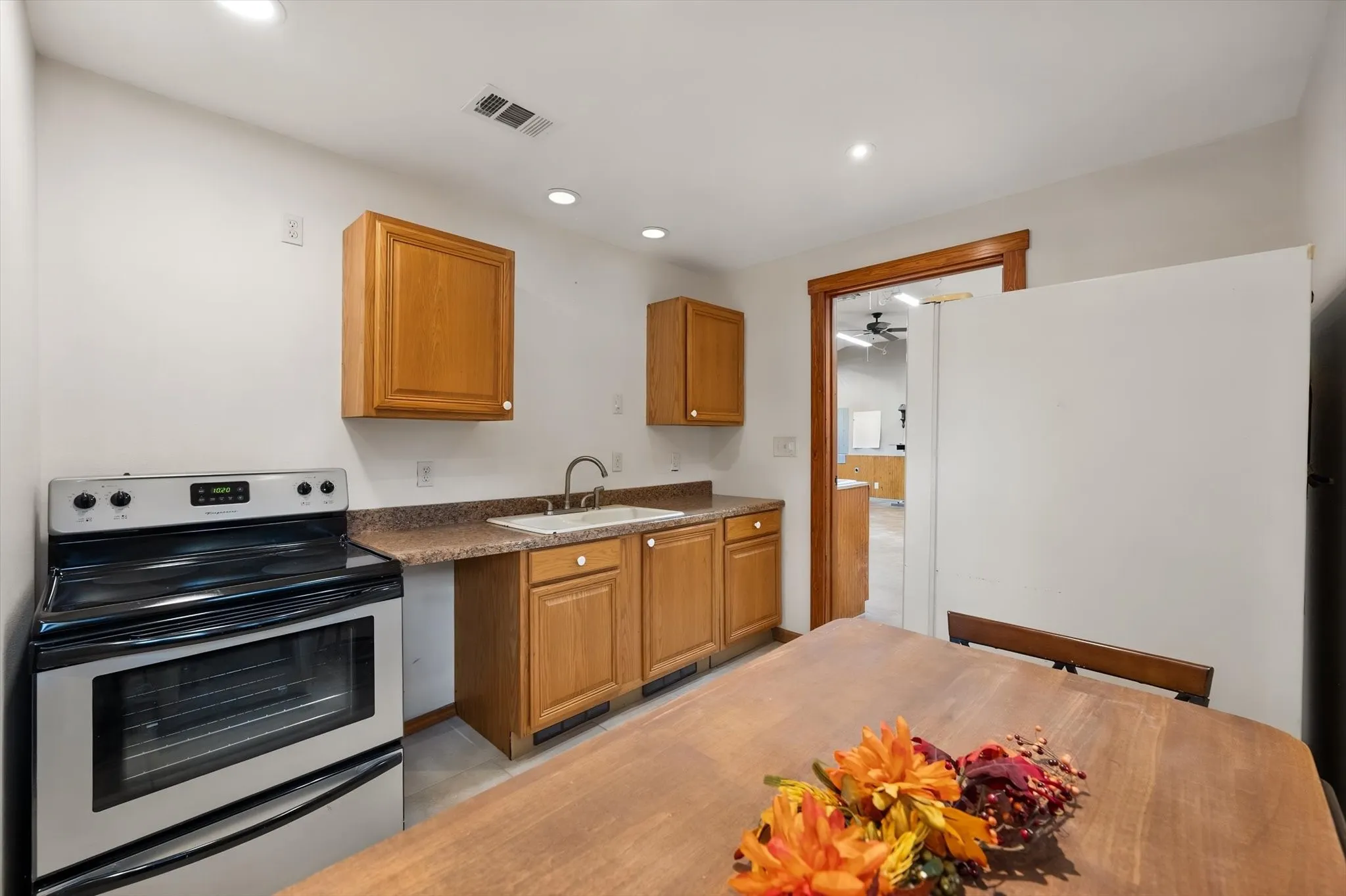 Kitchen area featuring wood cabinetry, a stainless steel range, and a single-basin sink