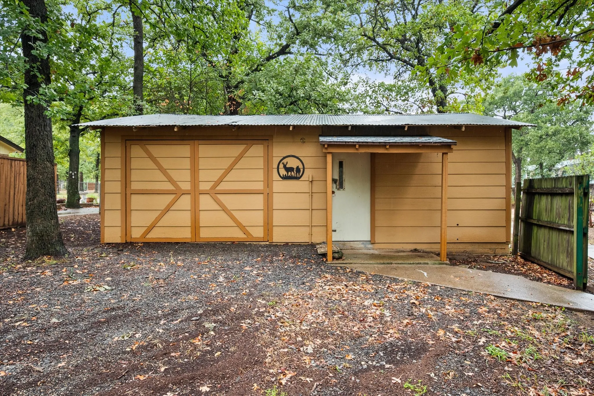 20x30 Corrugated metal roof, wood siding exterior, double barn doors, covered entry, and a side gate