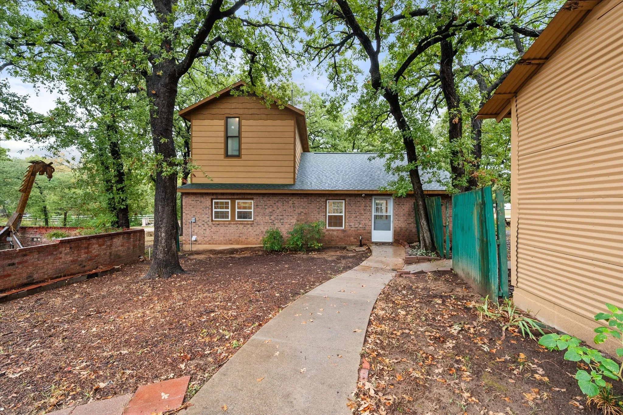 Two-story residence featuring a brick first level and horizontal siding on the second story