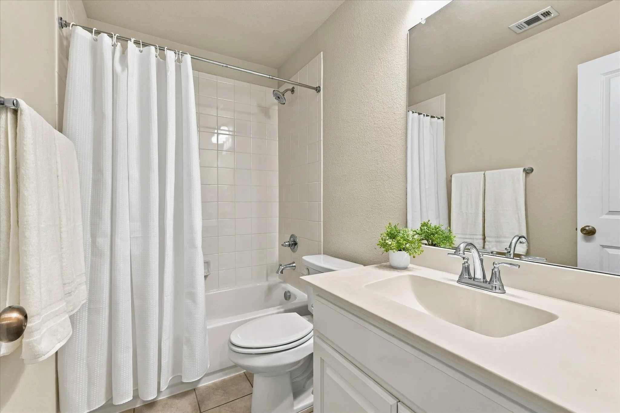 Bathroom featuring a vanity with an integrated sink, polished chrome faucet, and full-width mirror