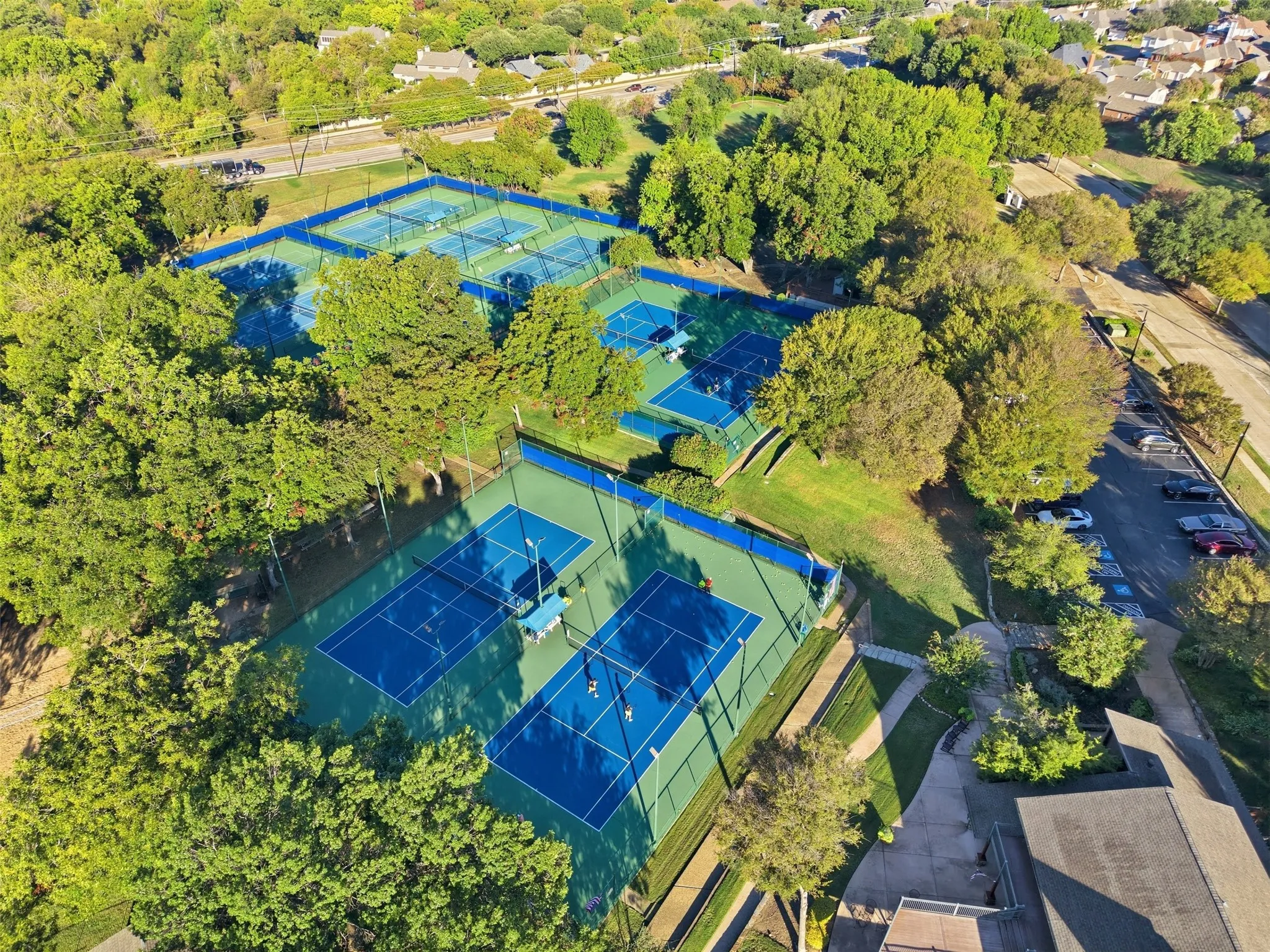Community outdoor tennis courts, surrounded by mature trees