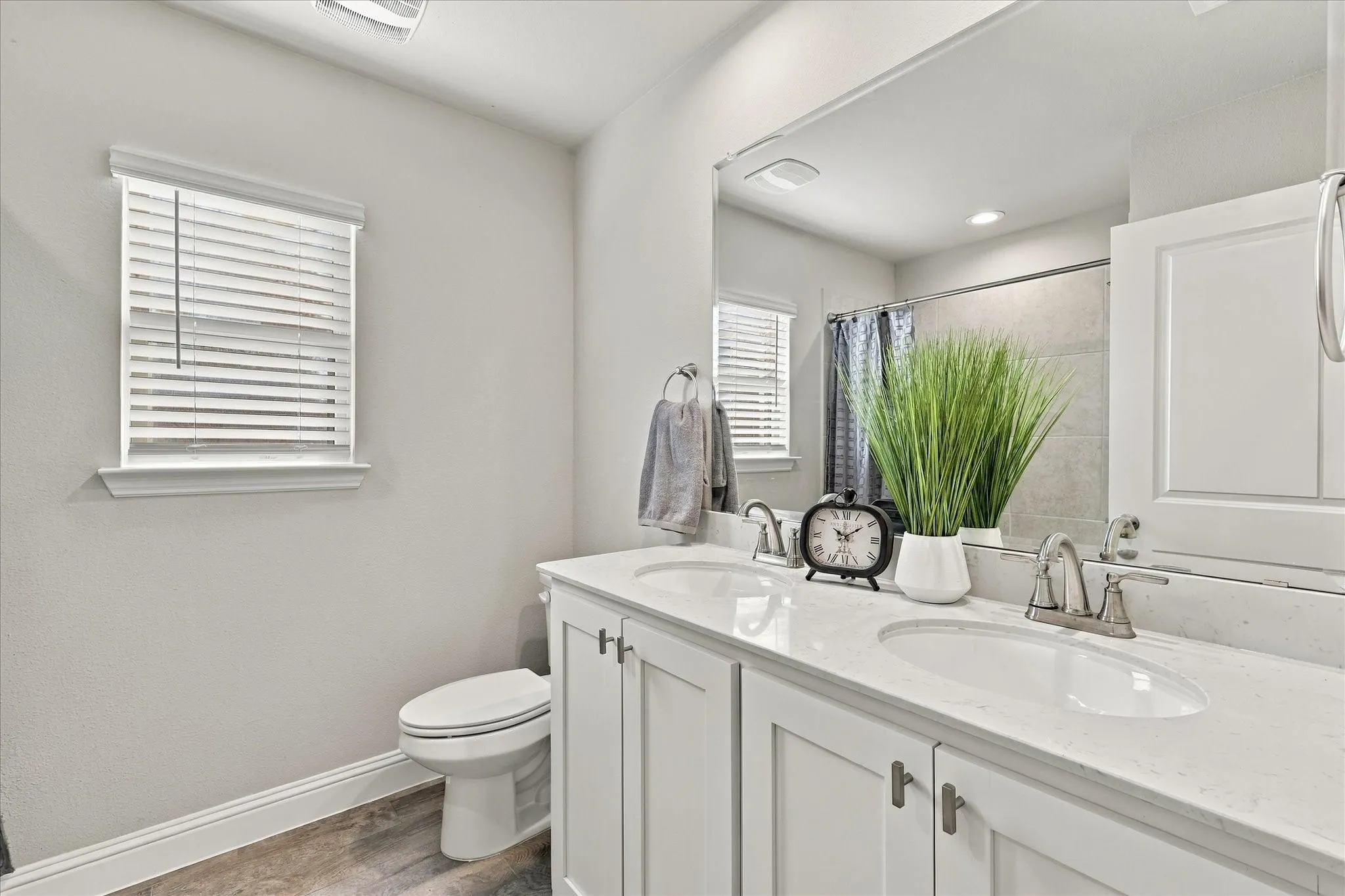 Dual vanity with undermount sinks, white cabinetry, and brushed nickel hardware