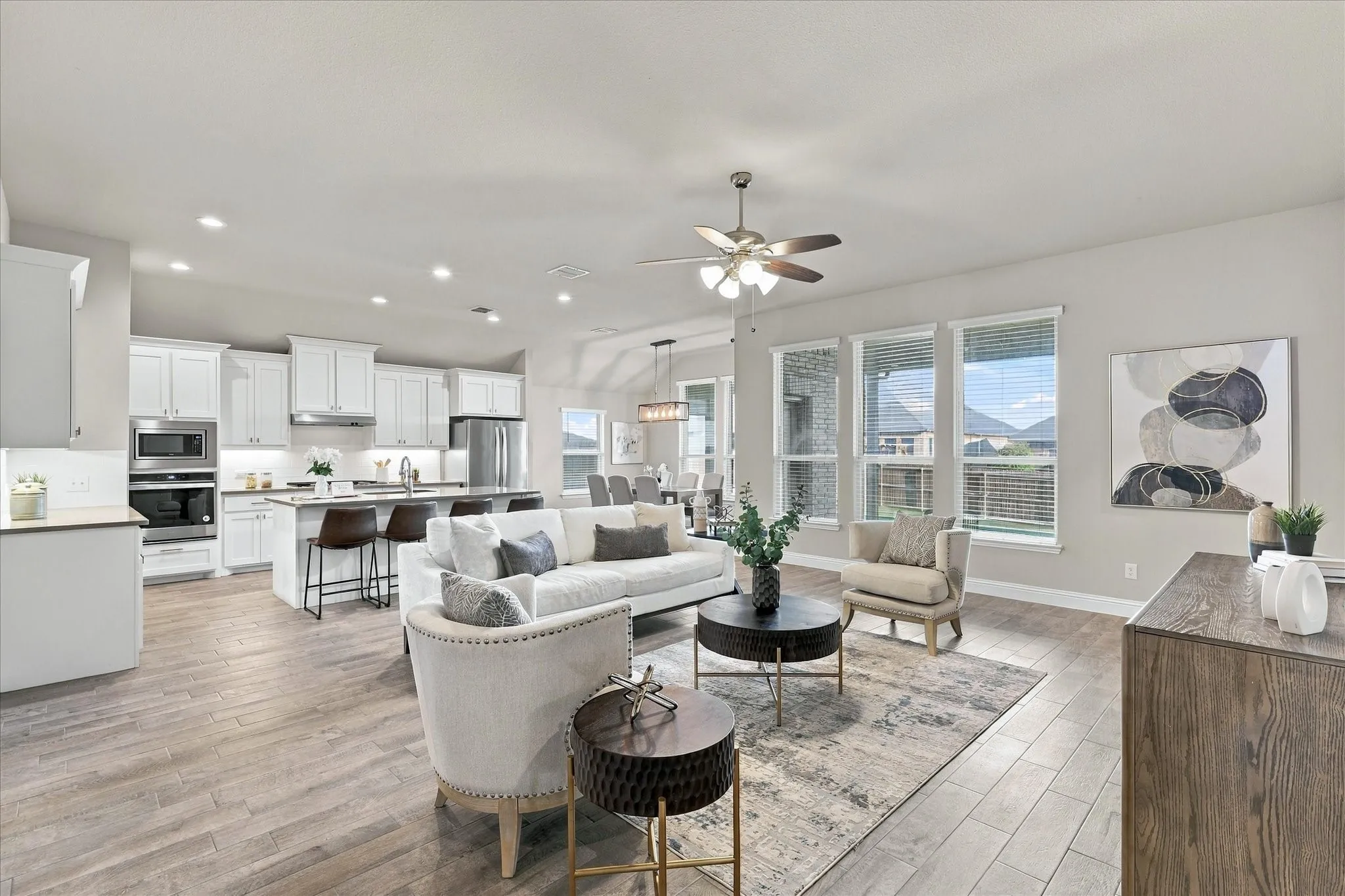 Open-concept living area featuring wood-finish flooring, recessed lighting, and a ceiling fan