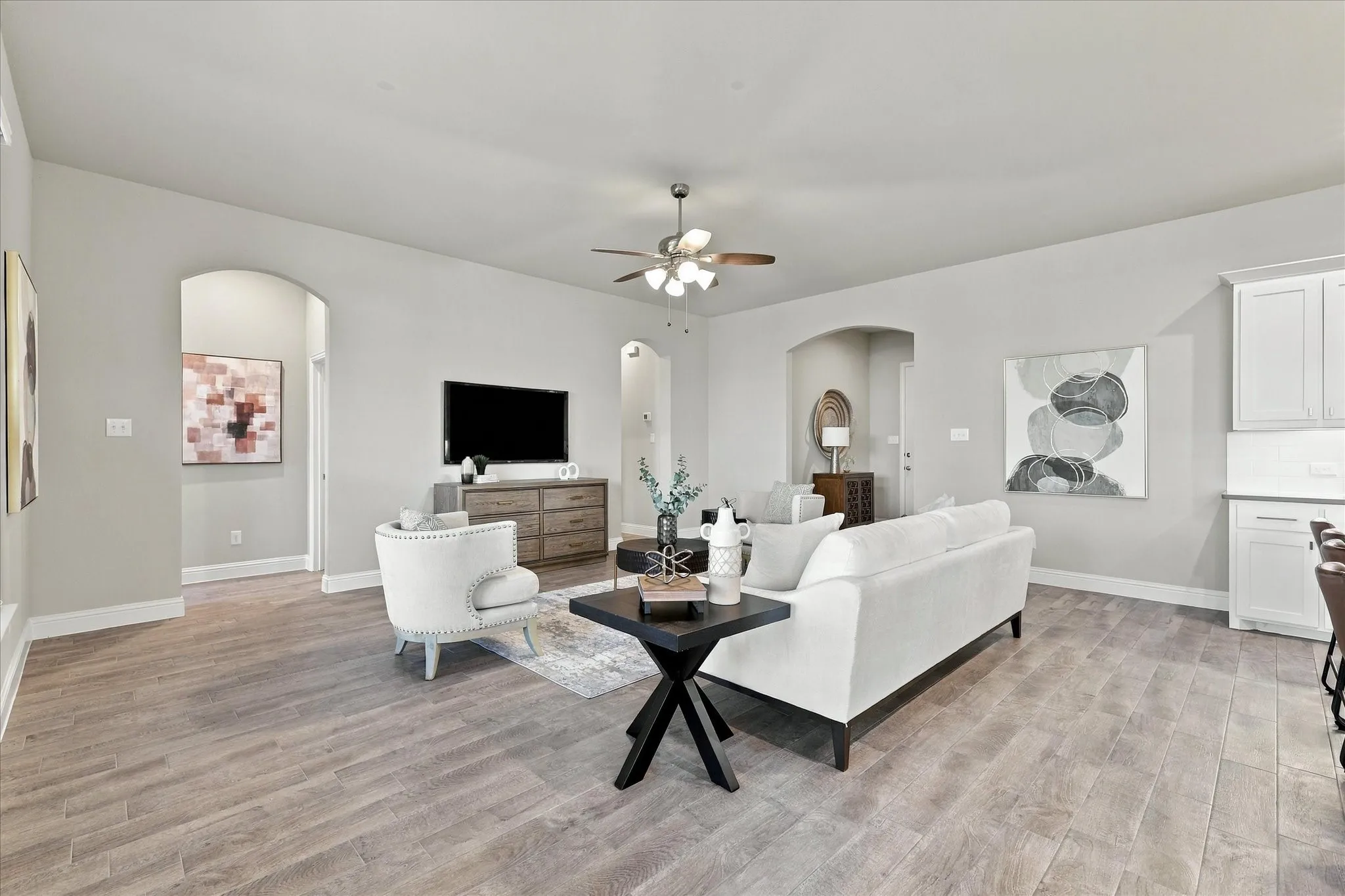 Open-concept living space featuring wood-finish flooring, recessed lighting, and an arched doorway