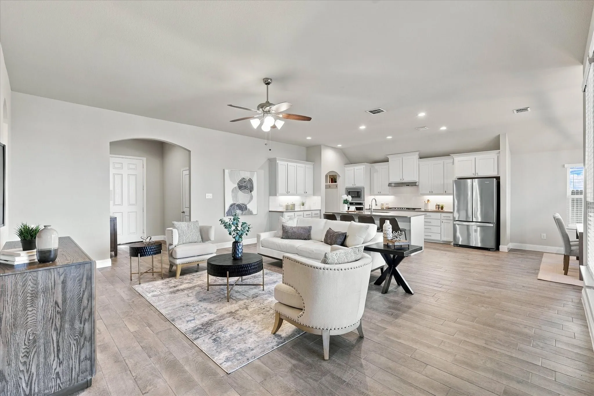 Open-concept living area featuring wood-finish flooring, recessed lighting, and a ceiling fan