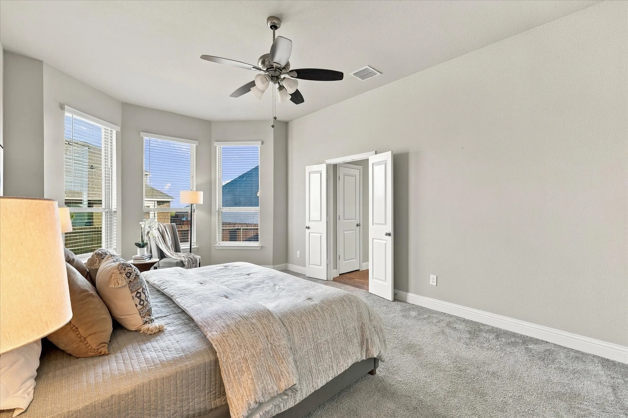 Recessed window bay, ceiling fan with integrated lighting, double-door entryway, and light-toned wall finishes