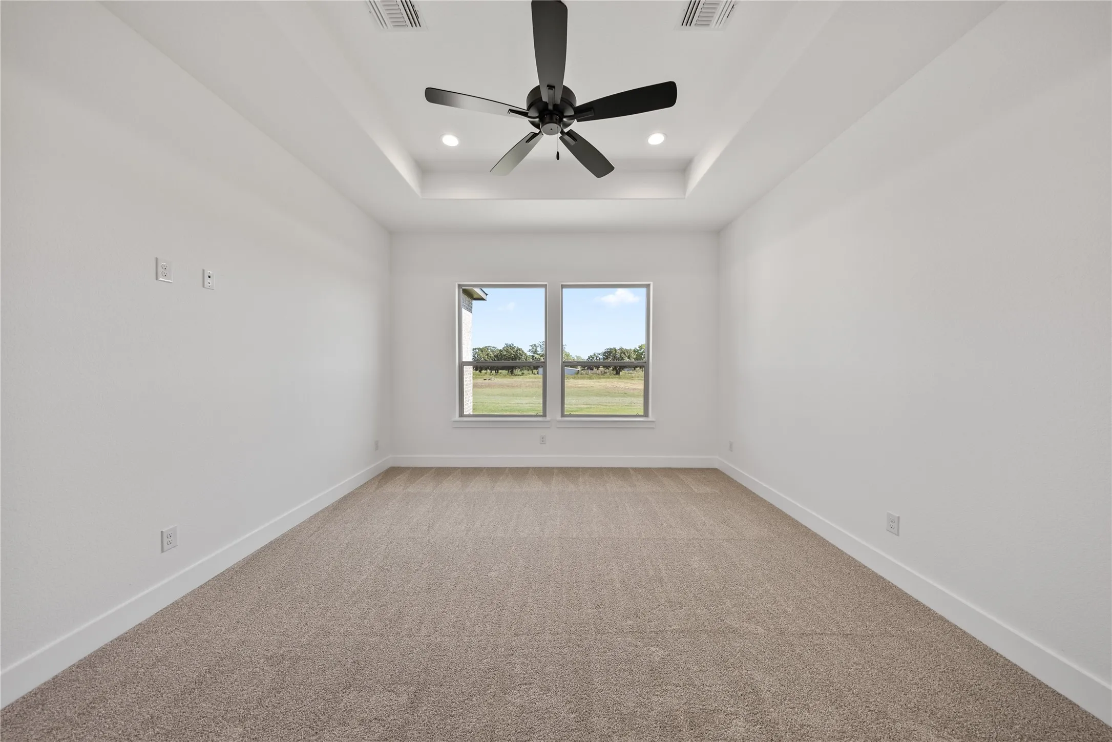 Recessed lighting, ceiling fan, tray ceiling, twin windows, wall-to-wall carpeting