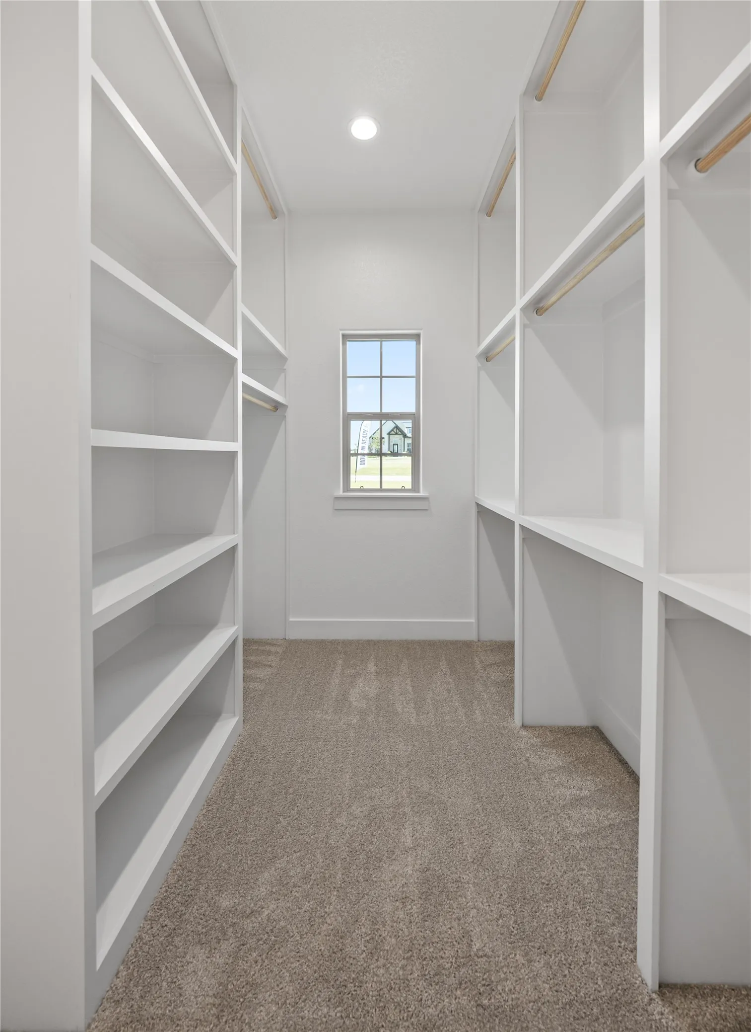Walk-in closet featuring extensive built-in shelving, hanging rods, recessed lighting, and a neutral carpet