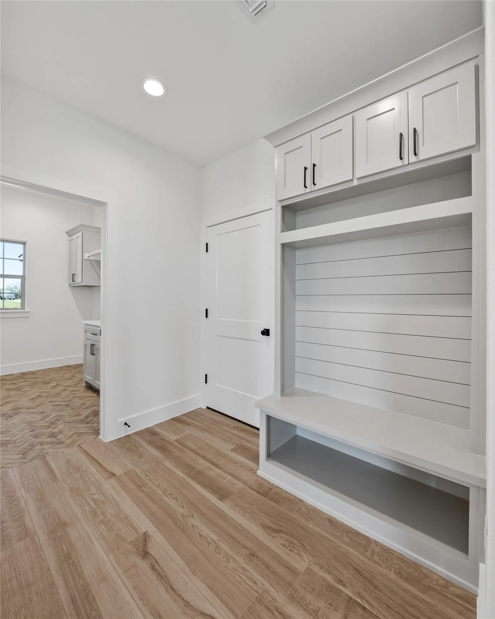 Built-in entryway storage with cabinetry and bench seating