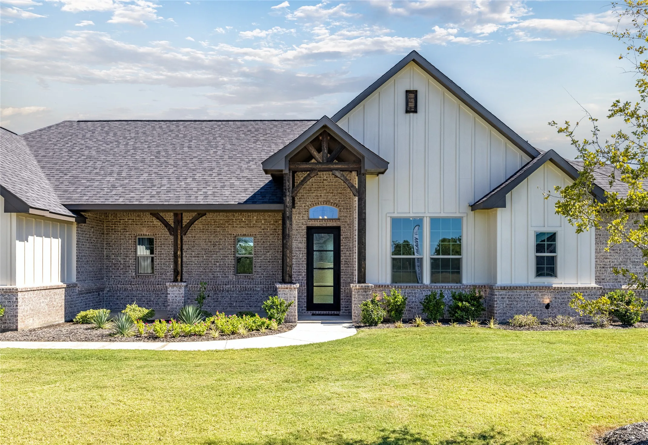 Brick and board-and-batten exterior with an arched entry