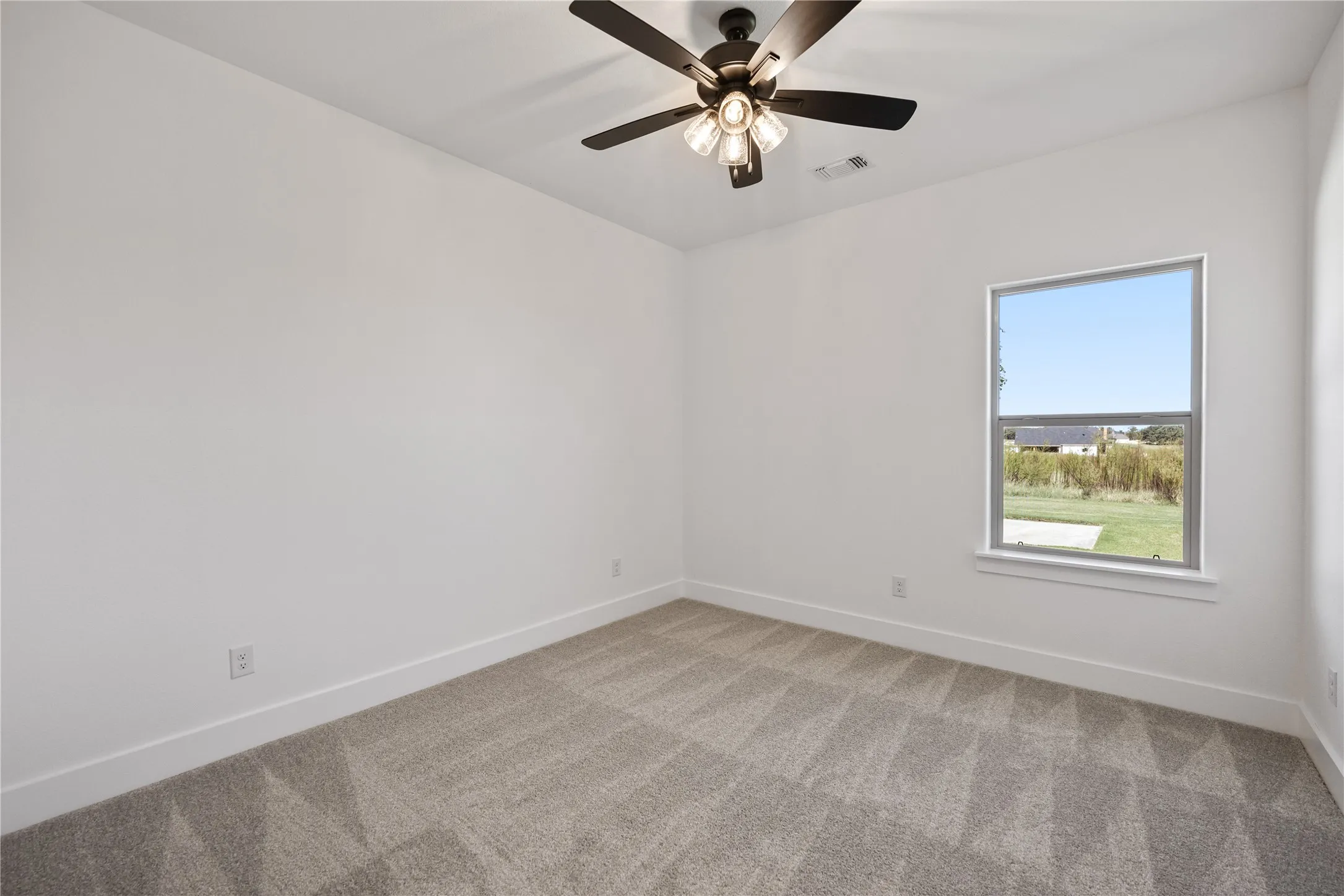 Neutral wall finishes, carpeted flooring, single window, and a ceiling fan with light fixture