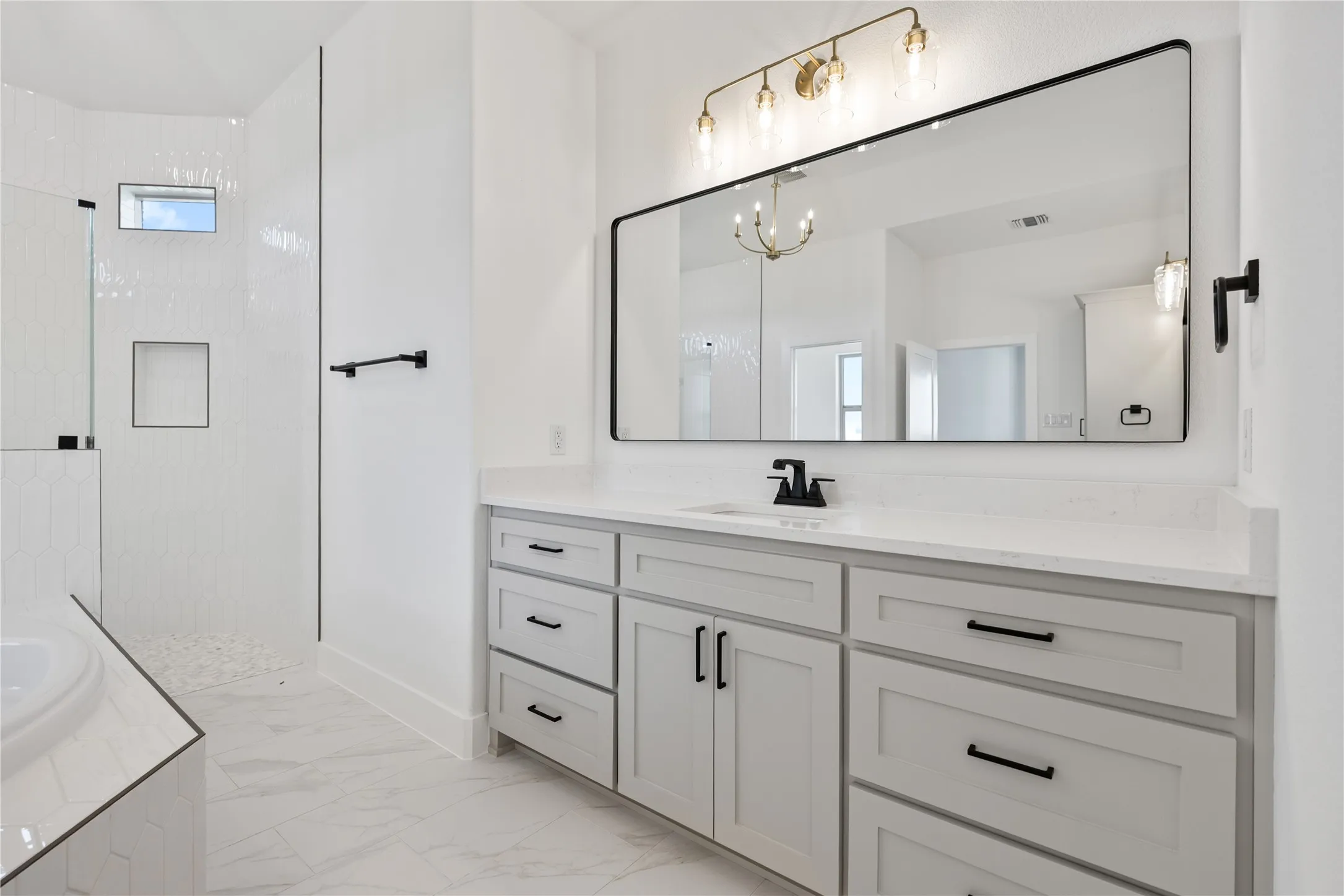 Dual vanity with light gray cabinetry, quartz countertop, and black hardware