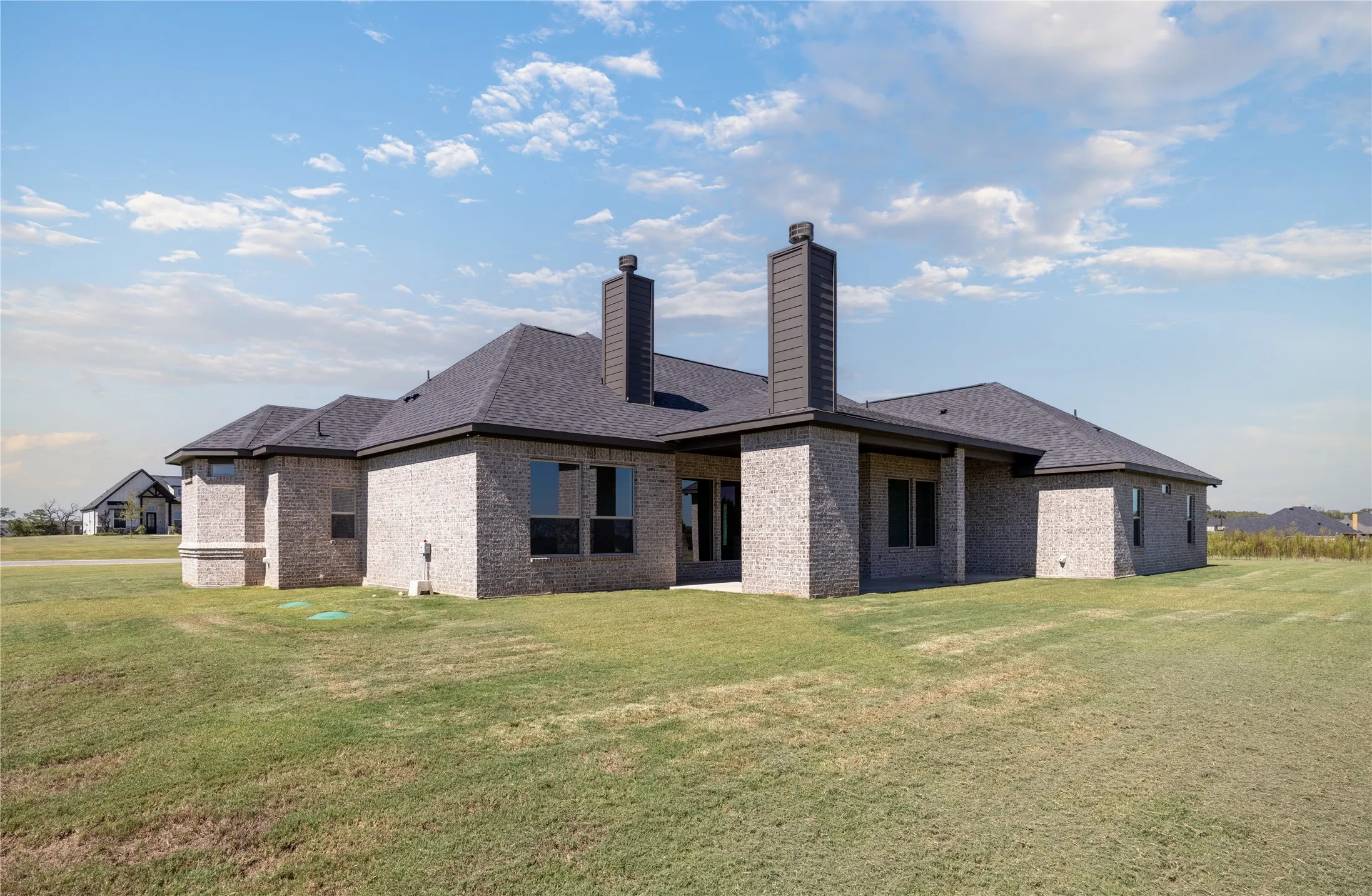 Brick exterior with dark gray roofing, multiple windows, and a structured chimney