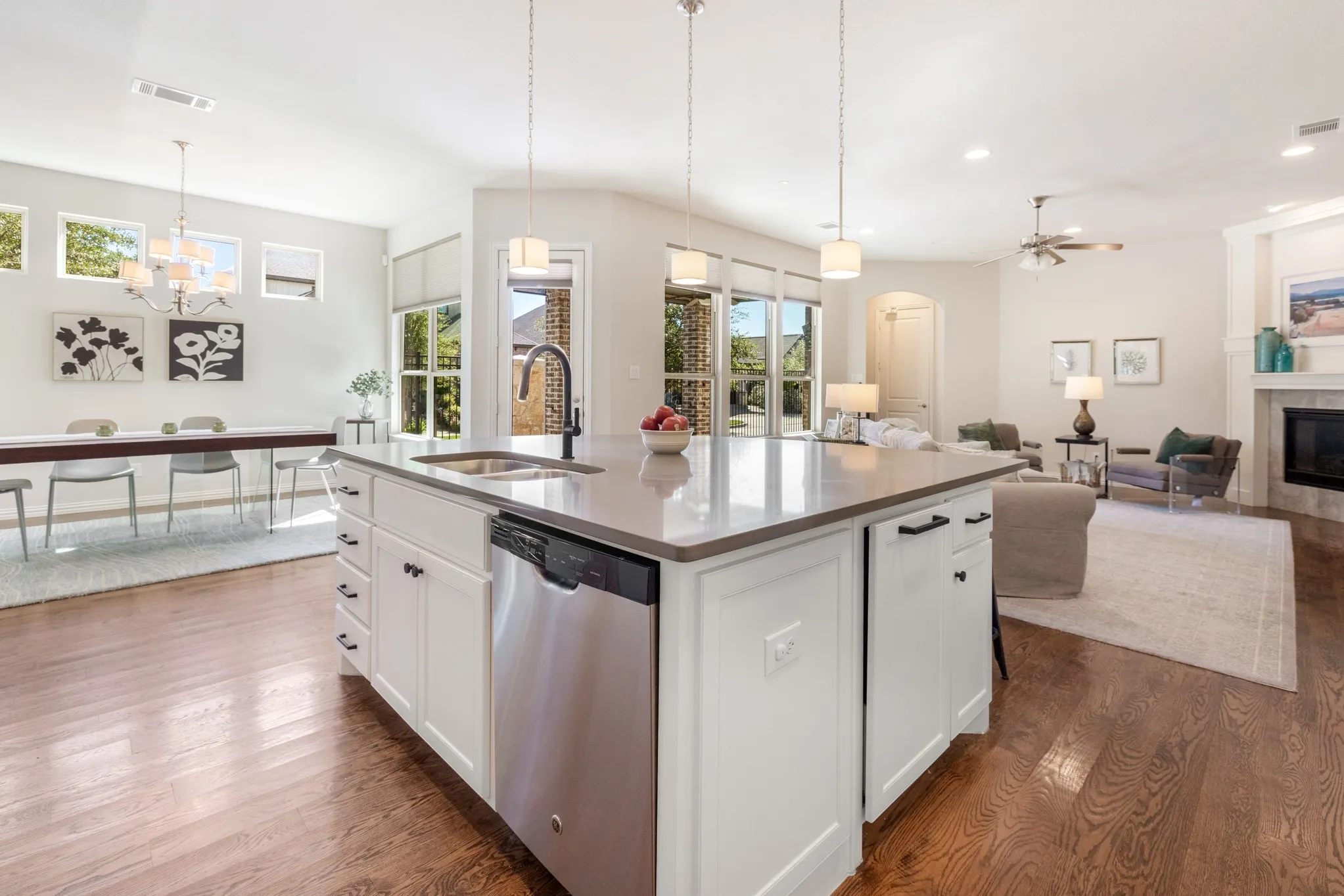 Kitchen island with integrated stainless steel dishwasher, undermount sink, and dark faucet