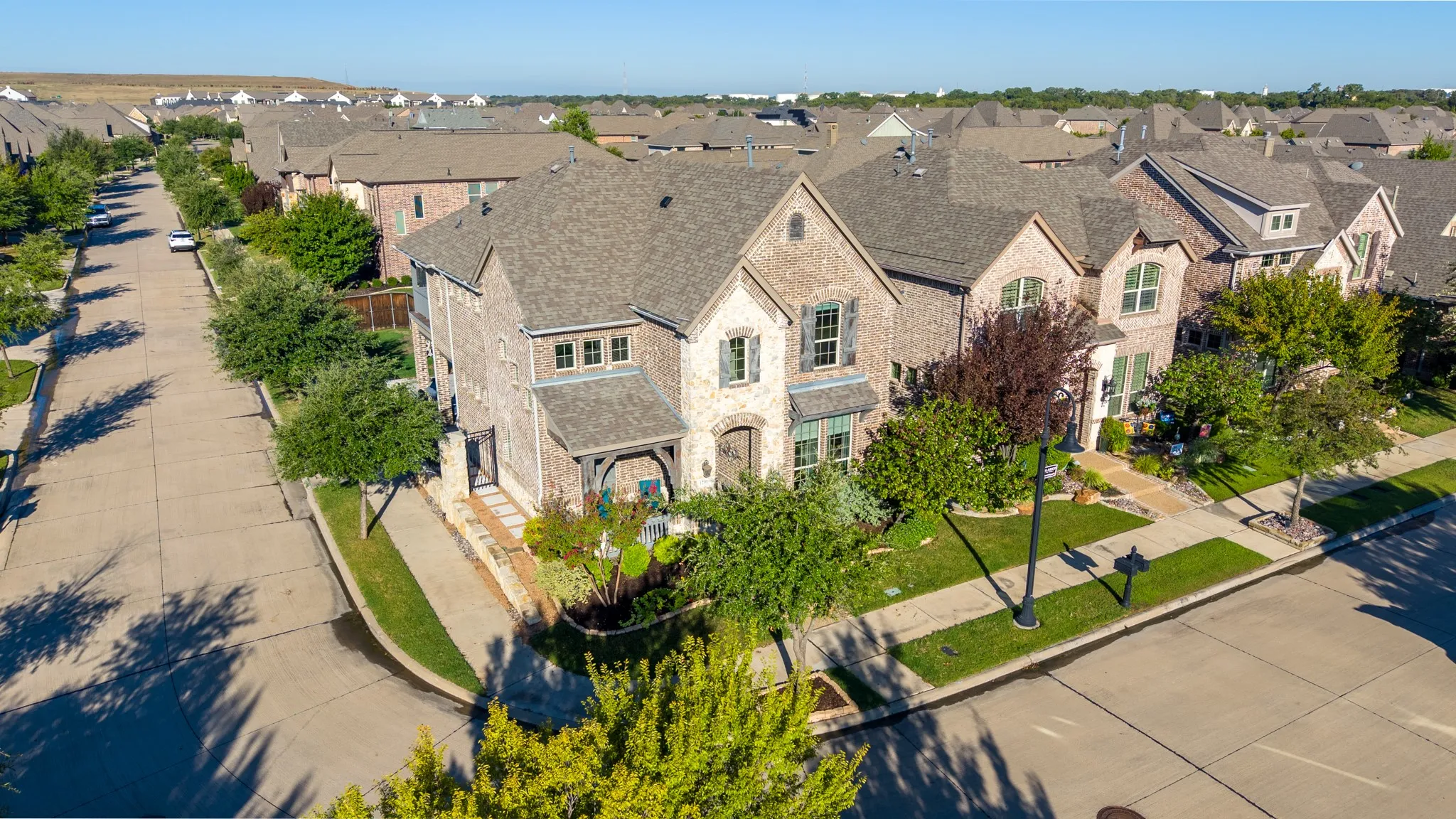 Corner lot residence featuring a brick exterior, multiple gables, and a covered entry porch
