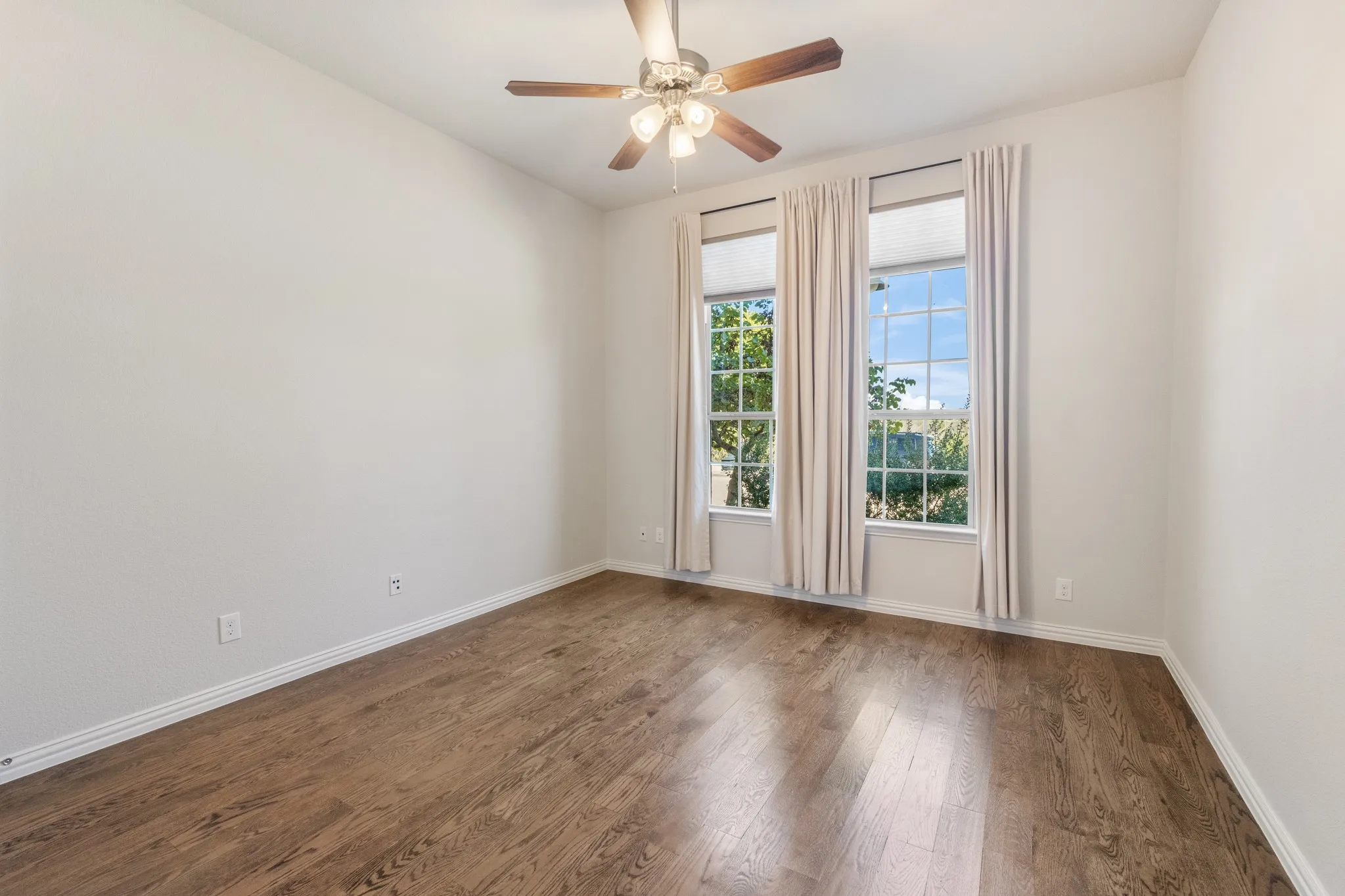 Downstairs bedroom/office. Wood-finish flooring, two large windows with lake views.