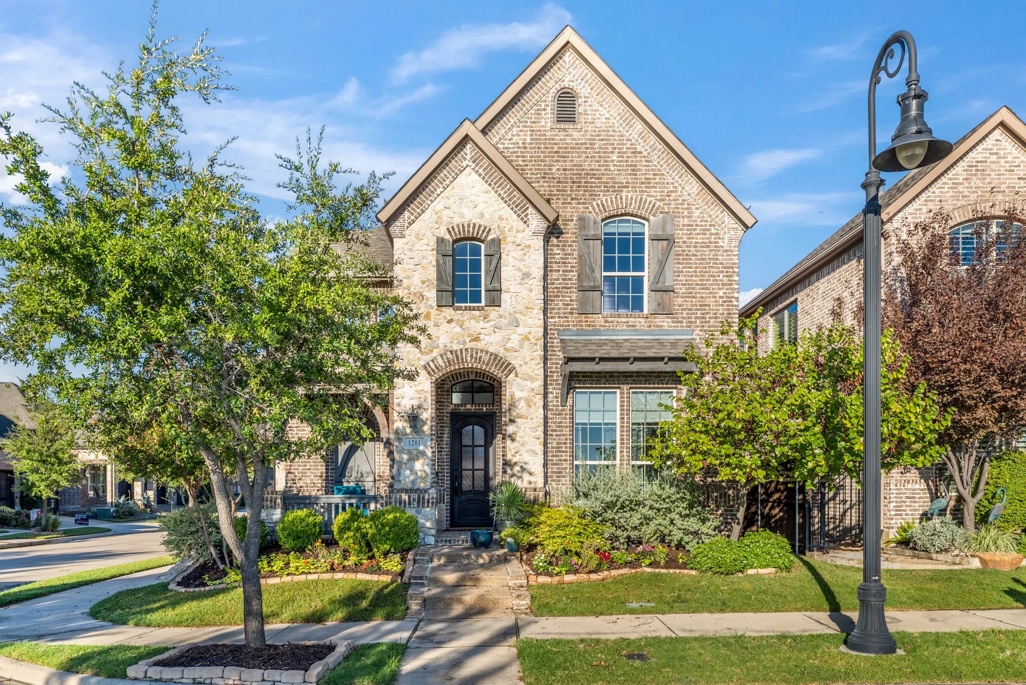 Brick and stone exterior with a prominent arched entry, complete with a dark-paneled front door
