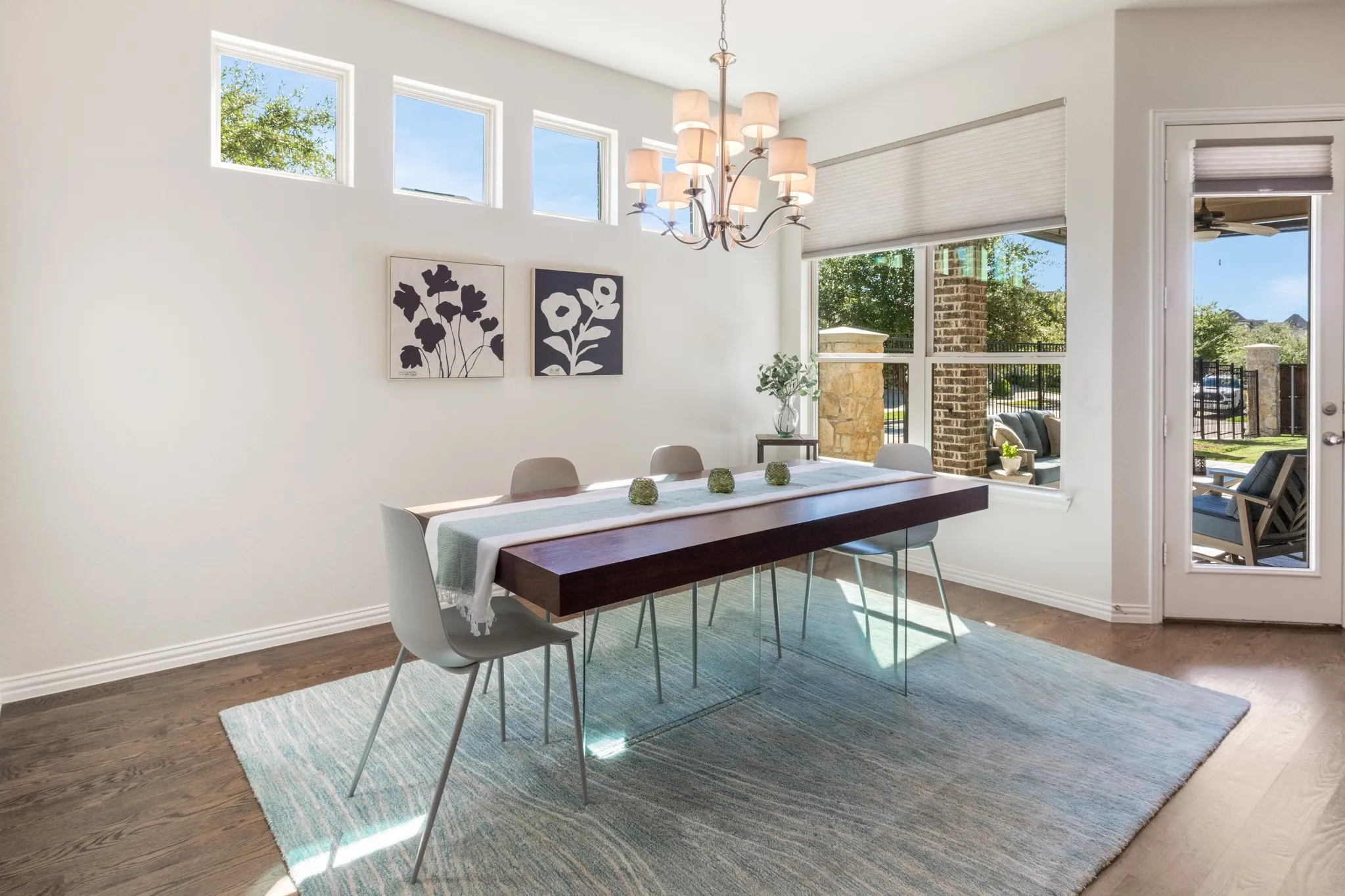 Wood-finish flooring with a multi-pane glass door, large windows, and transom windows