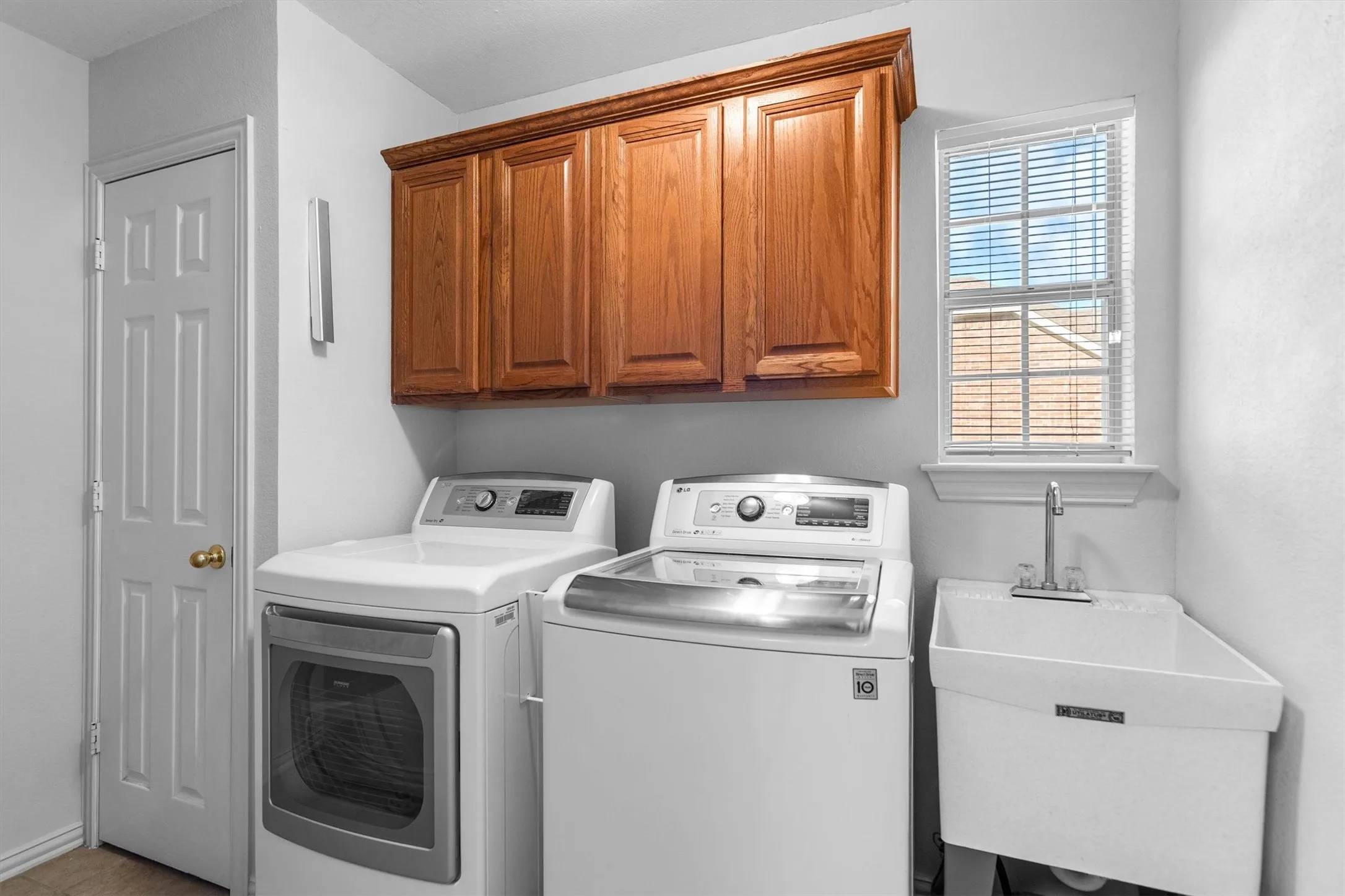 large laundry room with a sink and cabintry