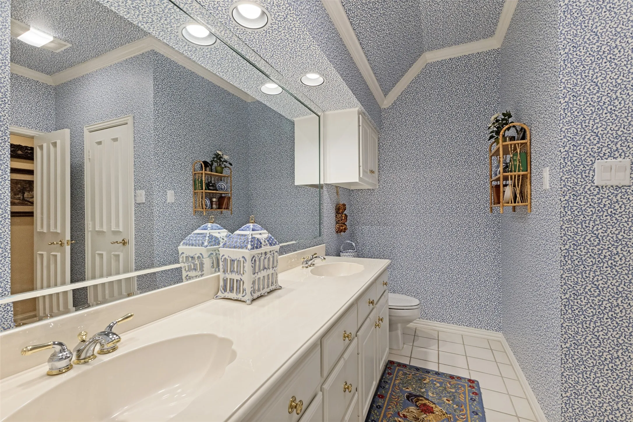 Dual vanity with under-mount sinks, white cabinetry, and a full-width mirror