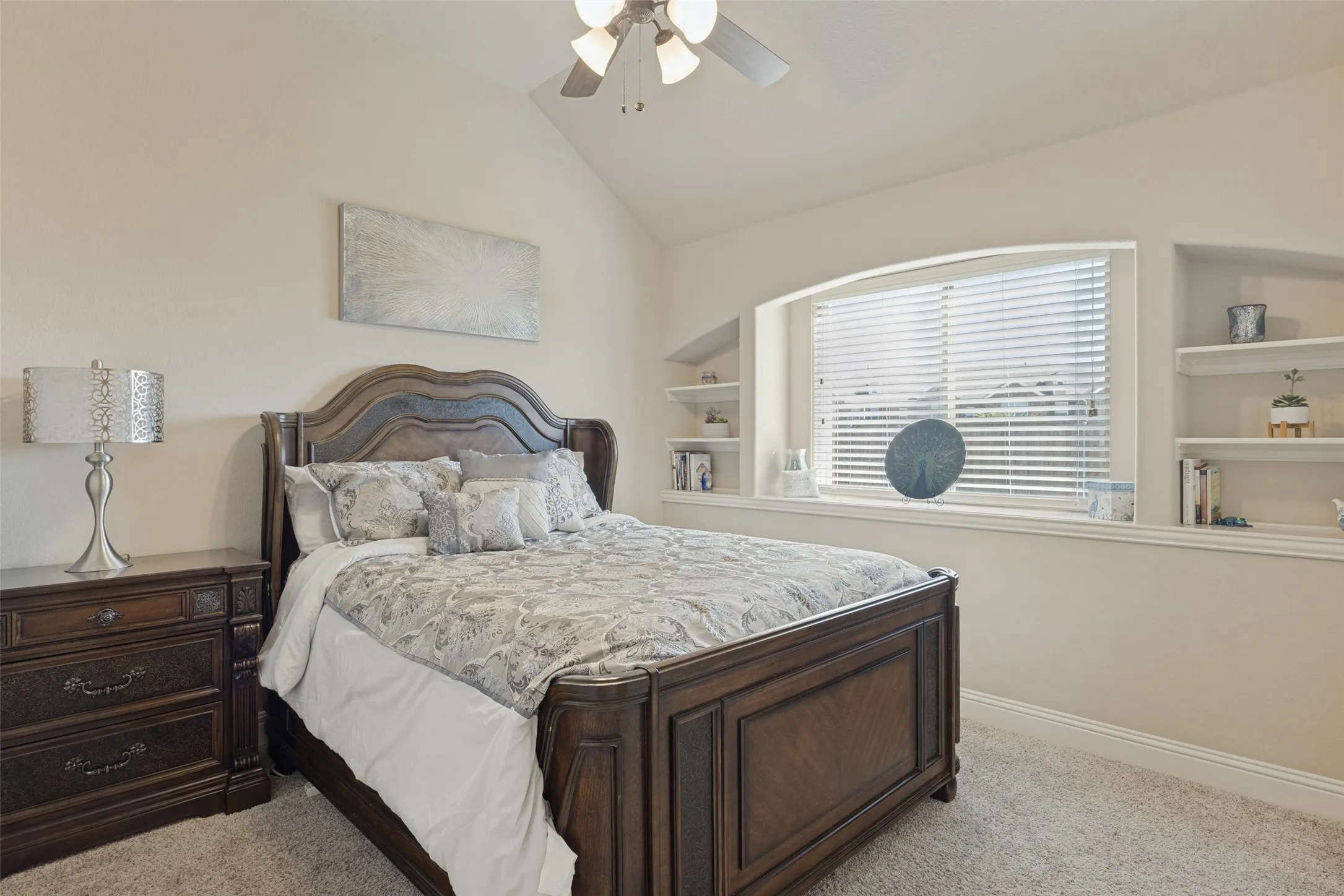 Secondary bedroom with shelves on both sides of large window,
