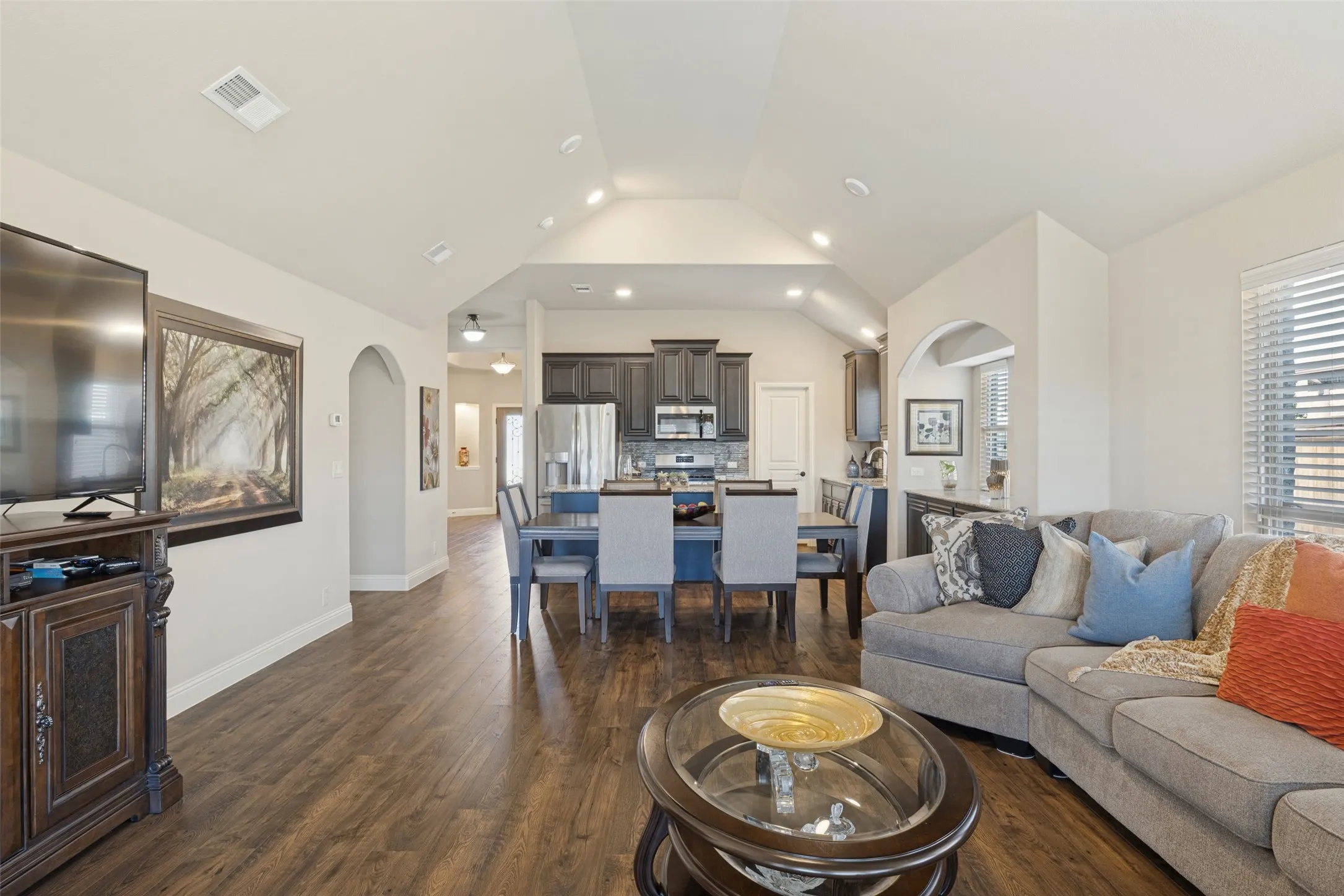 View from living area looking toward dining area and kitchen.  The home has arch entry way to bedrooms.